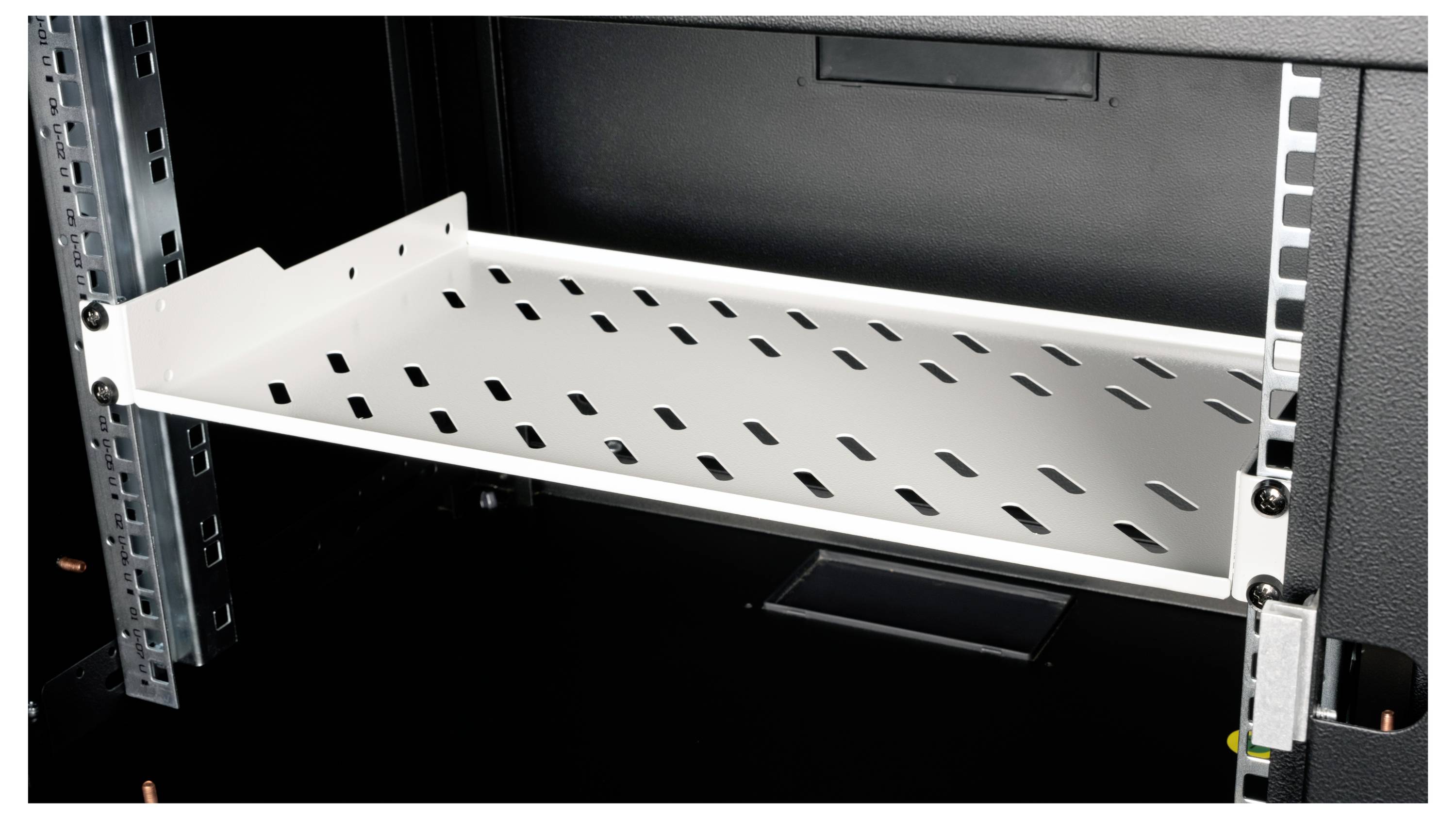 Ein Metallregal mit Lüftungsschlitzen ist in einem Server-Rack montiert. Es bietet Platz für Geräte und sorgt für Luftzirkulation.