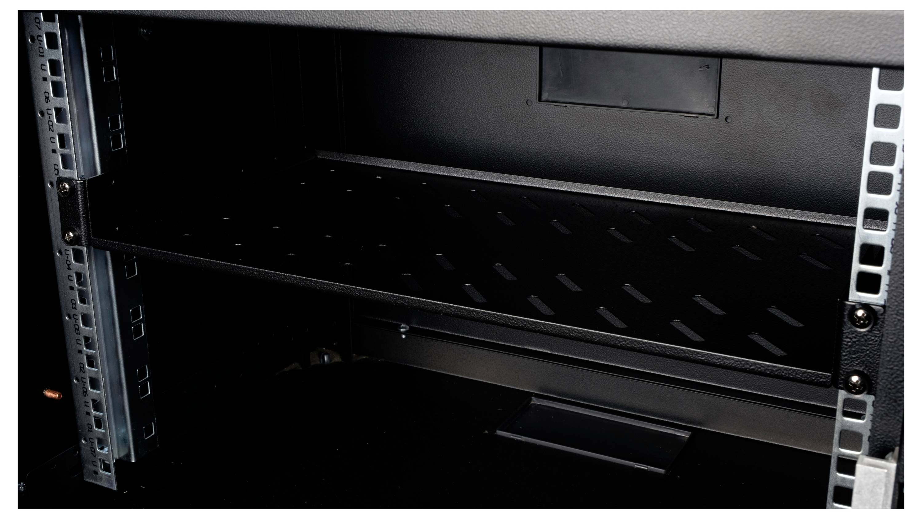 Ein leeres Metallregal in einem offenen Schrank, mit stabilen seitlichen Schienen und einer schwarzen Bodenplatte.