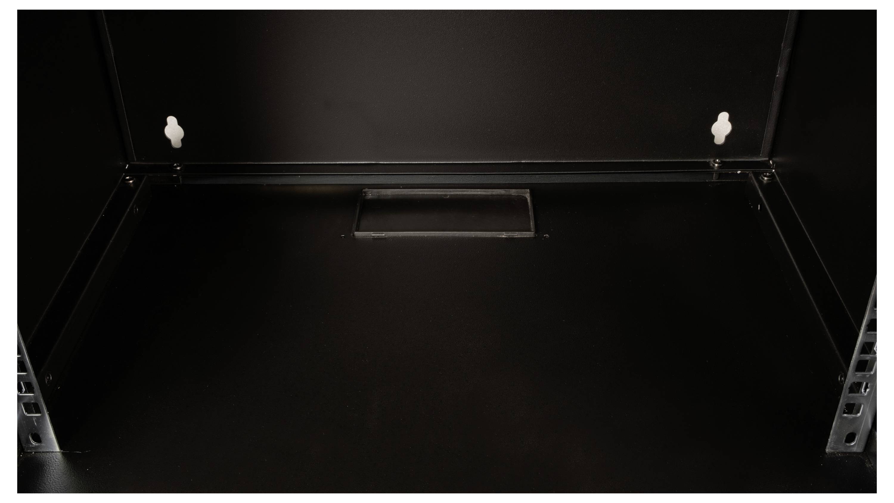 Das Bild zeigt das Innere eines leeren schwarzen Schranks mit zwei Haken an der Rückwand und einem rechteckigen Ausschnitt in der Mitte der unteren Wand.