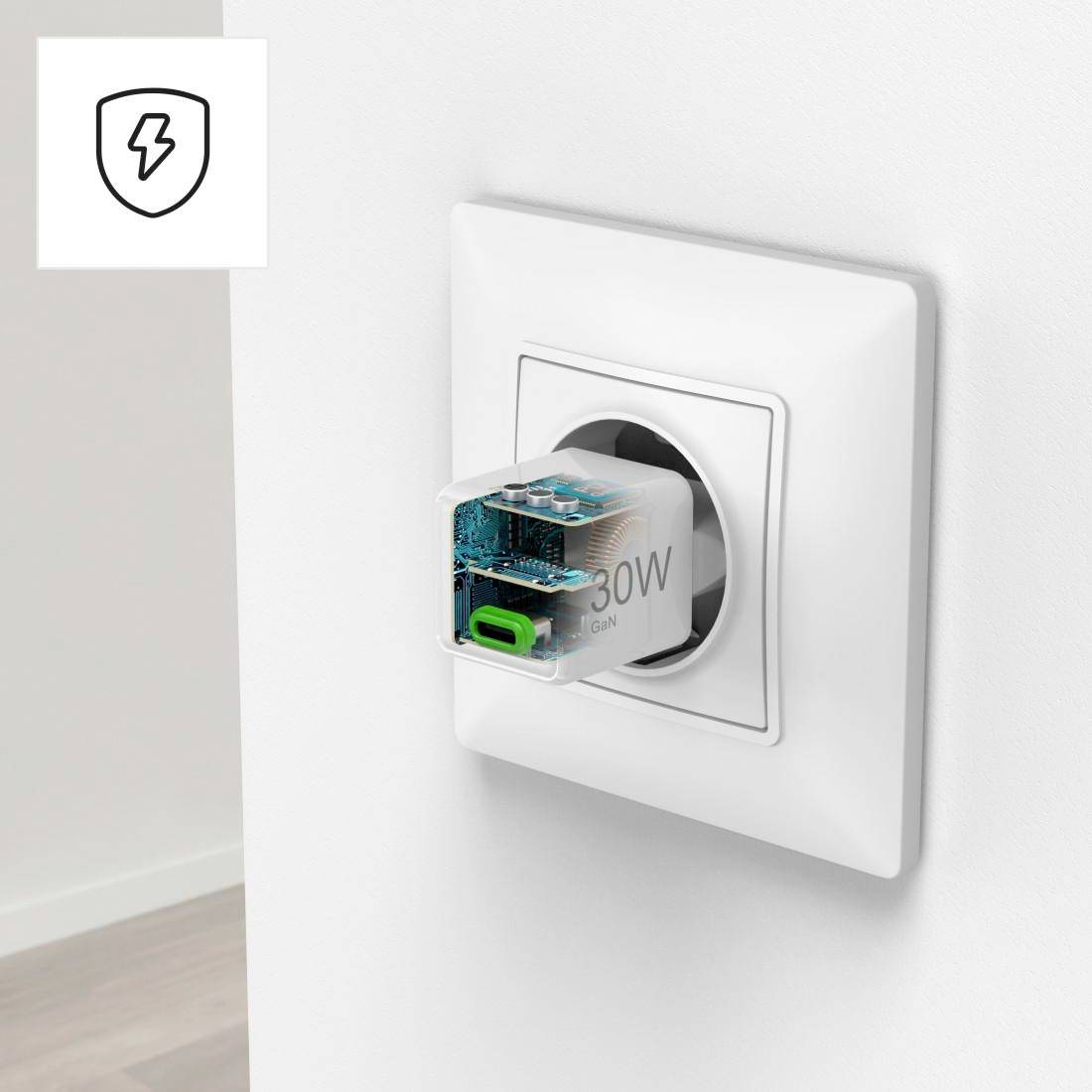 Ein moderner Steckeradapter steckt in einer Wandsteckdose, zeigt technischen Aufbau durch transparentes Gehäuse. Oben links Blitzsymbol.