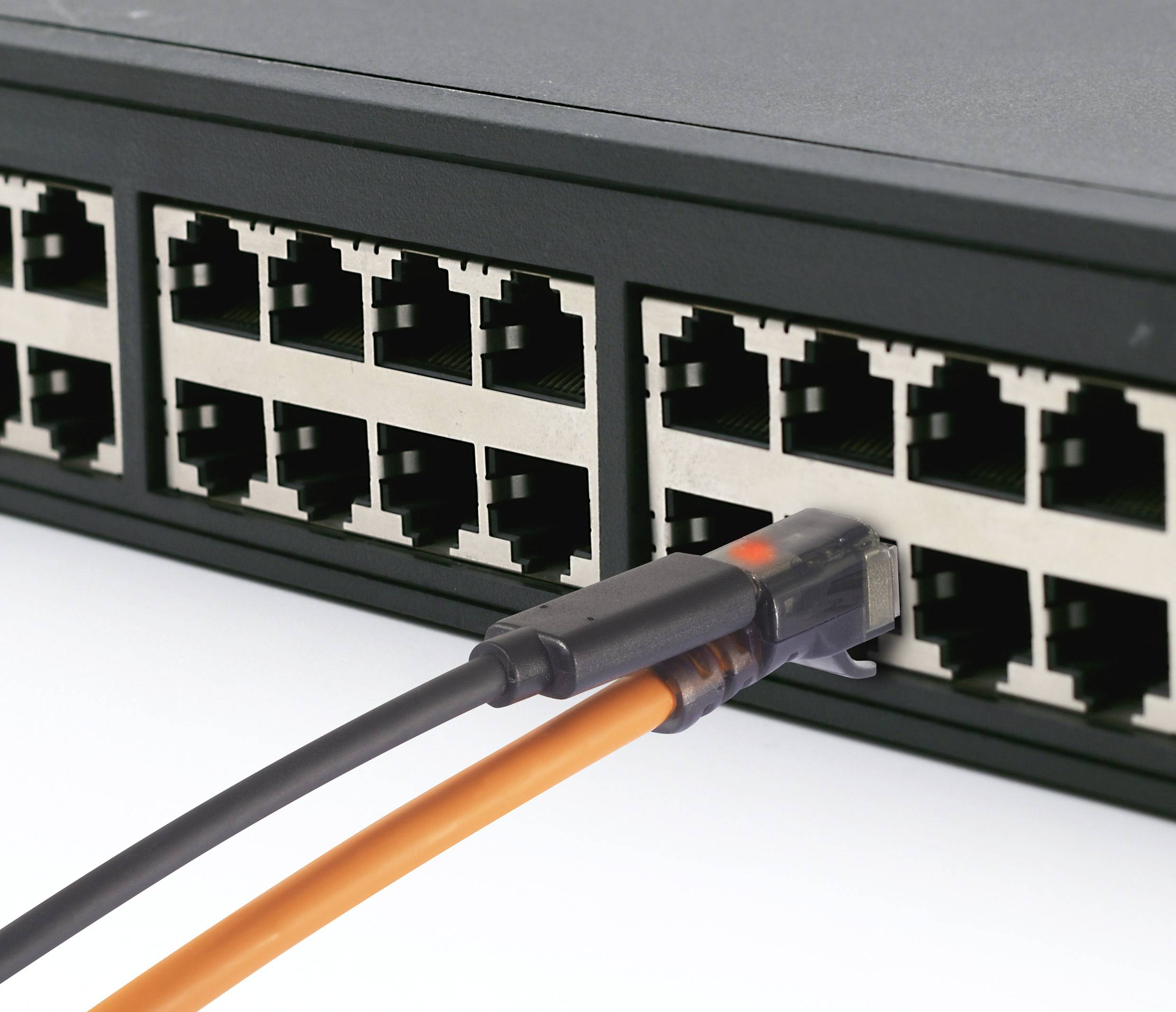 Ein schwarzer Netzwerk-Switch mit einem orangenen Ethernet-Kabel, das in einen der Ports eingesteckt ist.