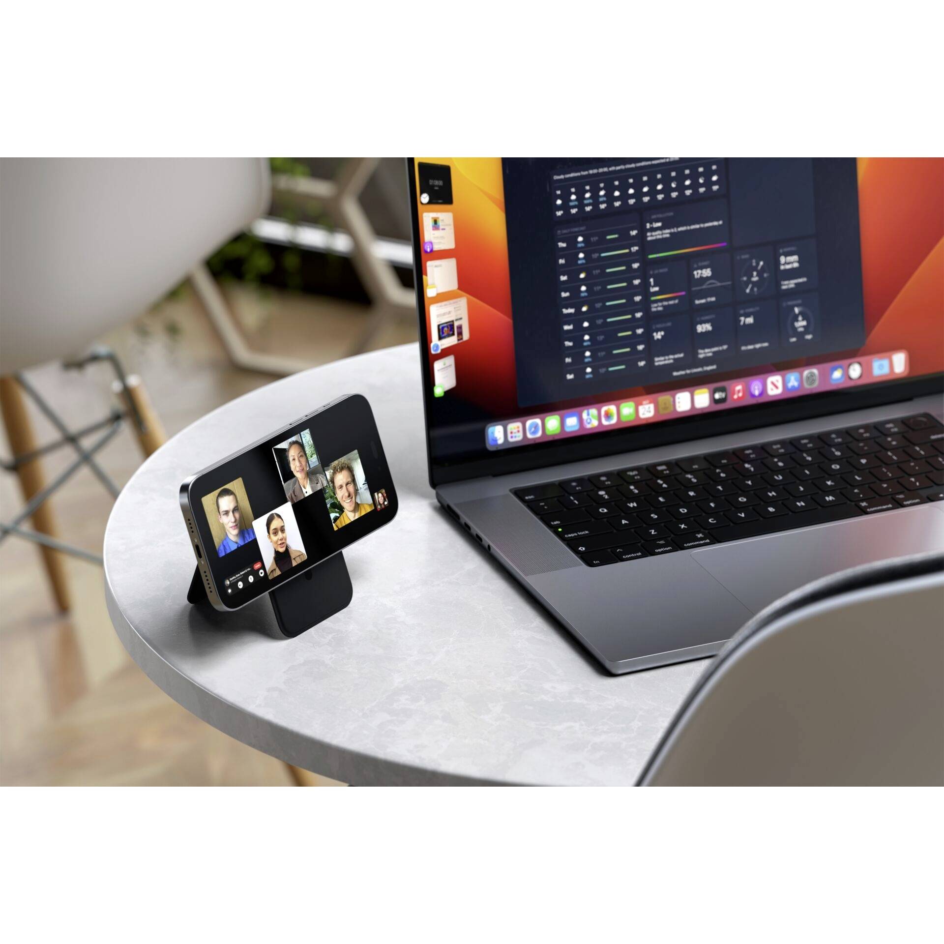 Ein Laptop zeigt Programmiercode; daneben ein Handy auf einem Ständer mit einem Videokonferenz-Call, vier Personen sind sichtbar.