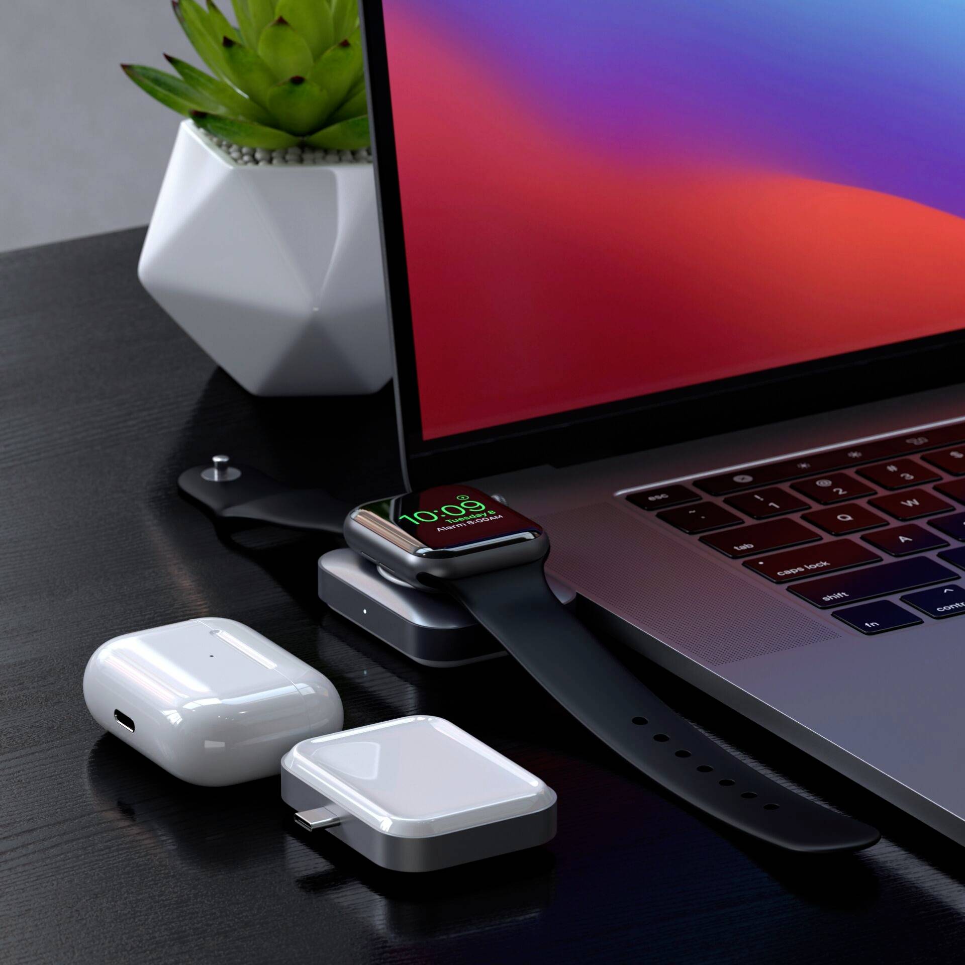 Auf einem Tisch liegen ein Laptop, eine Smartwatch, kabellose Ohrhörer und Ladezubehör. Die Uhr zeigt '10:09' an.