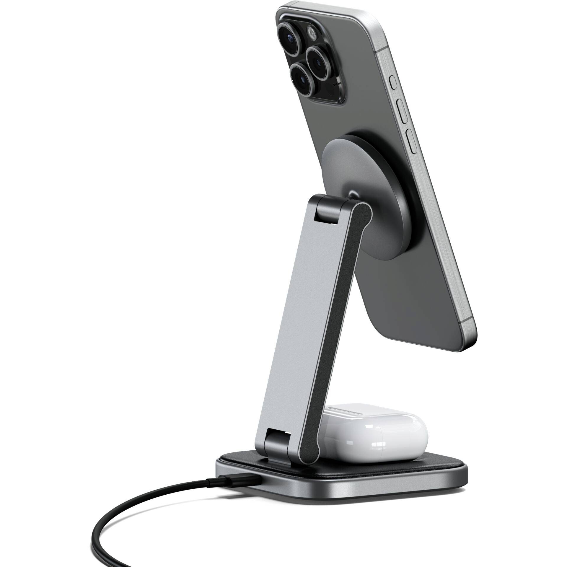 Ein Smartphone steht in einer metallischen Ladestation, gekippt. Darunter liegen kabellose Ohrhörer, ebenfalls aufgeladen.