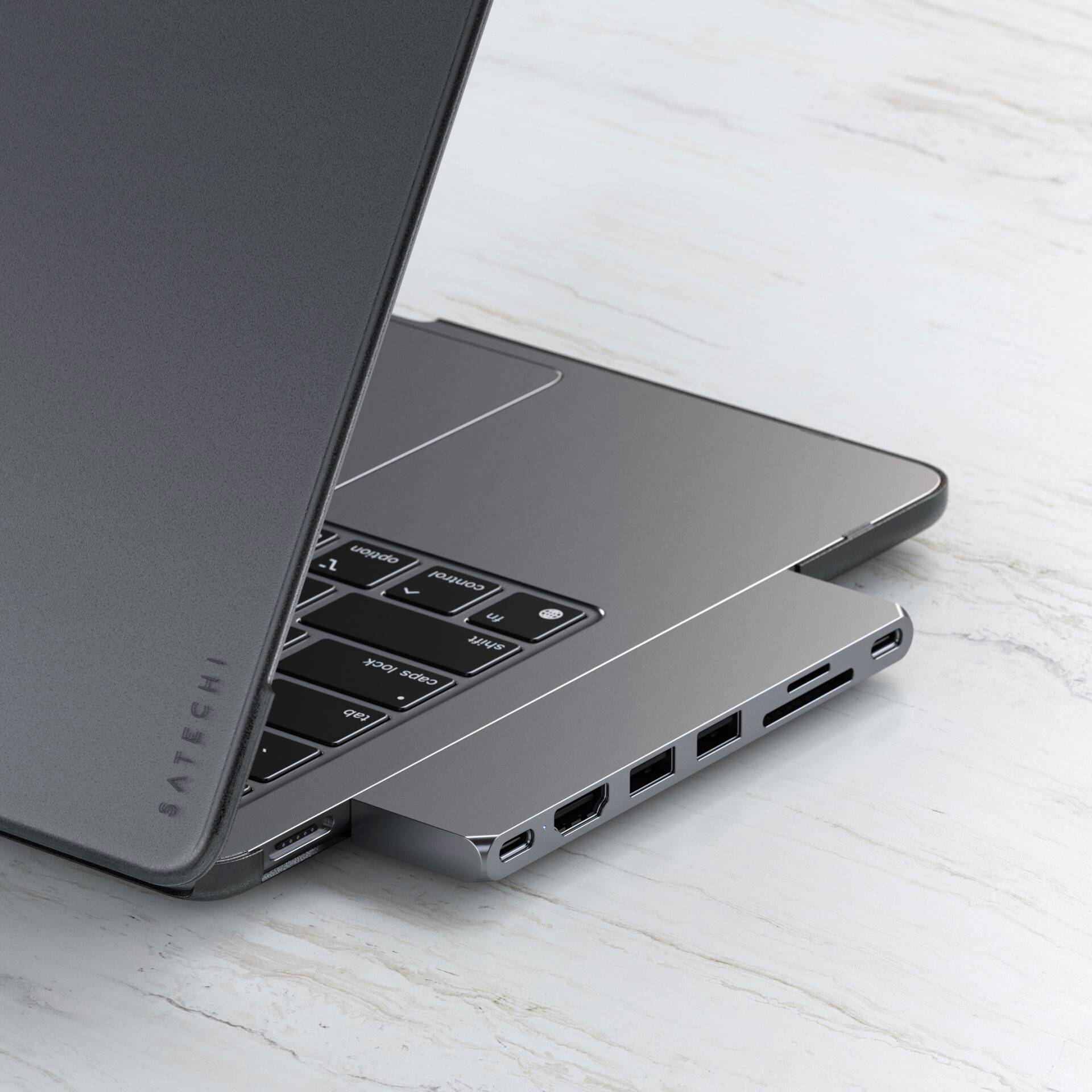 Ein Laptop mit einem USB-C-Hub an der Seite, der zusätzliche Ports bietet. Der Hub erweitert die Anschlussmöglichkeiten des Laptops.