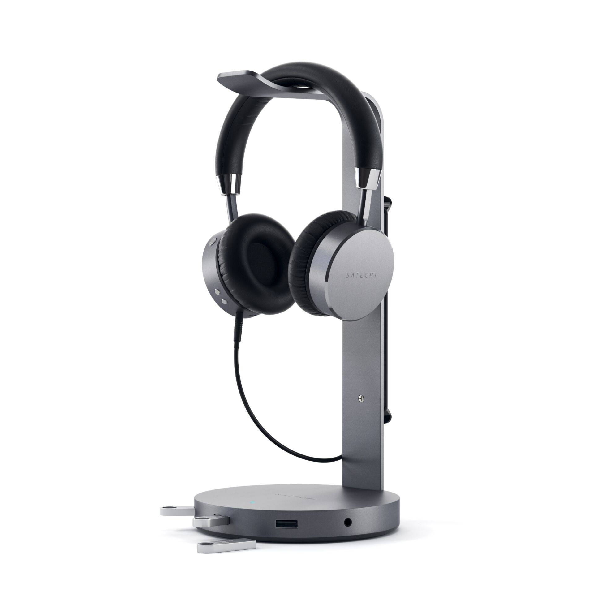Ein schwarzes Headset hängt auf einem eleganten, metallischen Ständer. Der Ständer hat eine breite Basis und lädt das Headset auf.