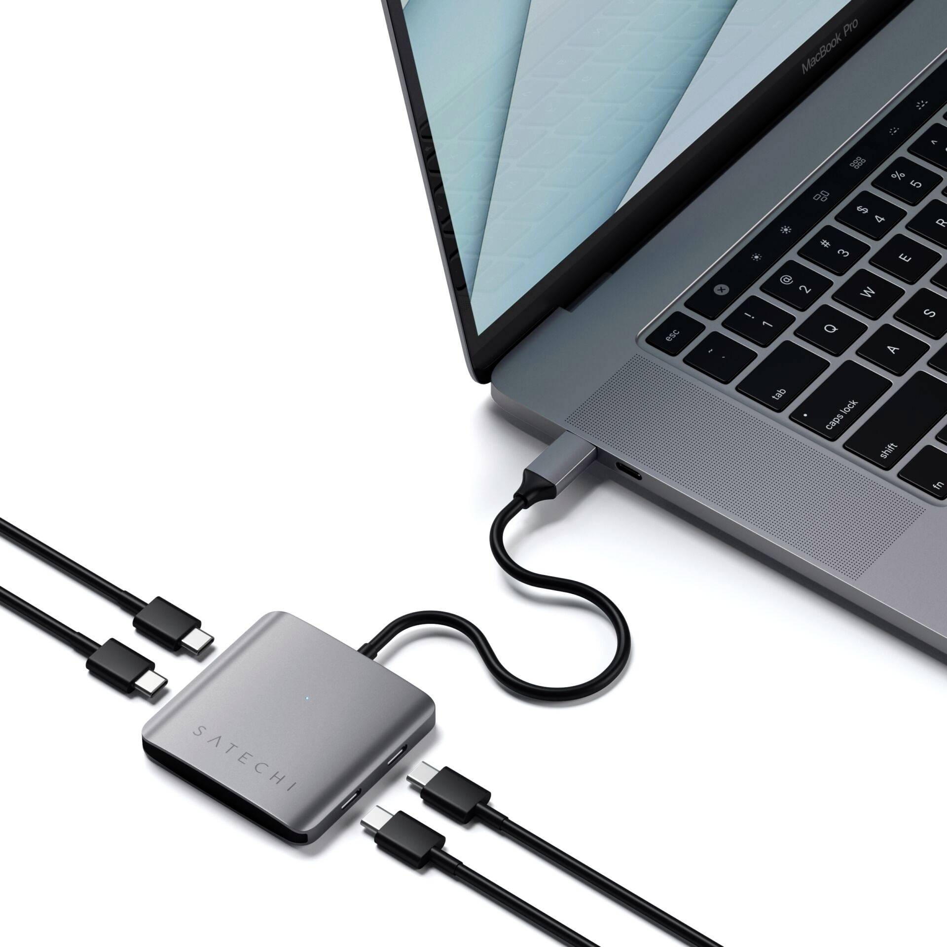 Ein Laptop wird über mehrere Kabel mit einem externen Satechi-Adapter verbunden. Der Adapter bietet erweiterte Anschlussmöglichkeiten.