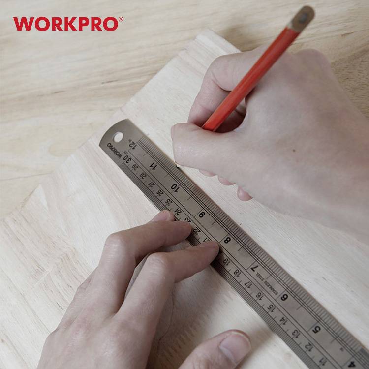 Eine Hand hält einen roten Stift und misst mit einem Lineal auf einem Holzbrett. Im Hintergrund steht 'WORKPRO' in roter Schrift.