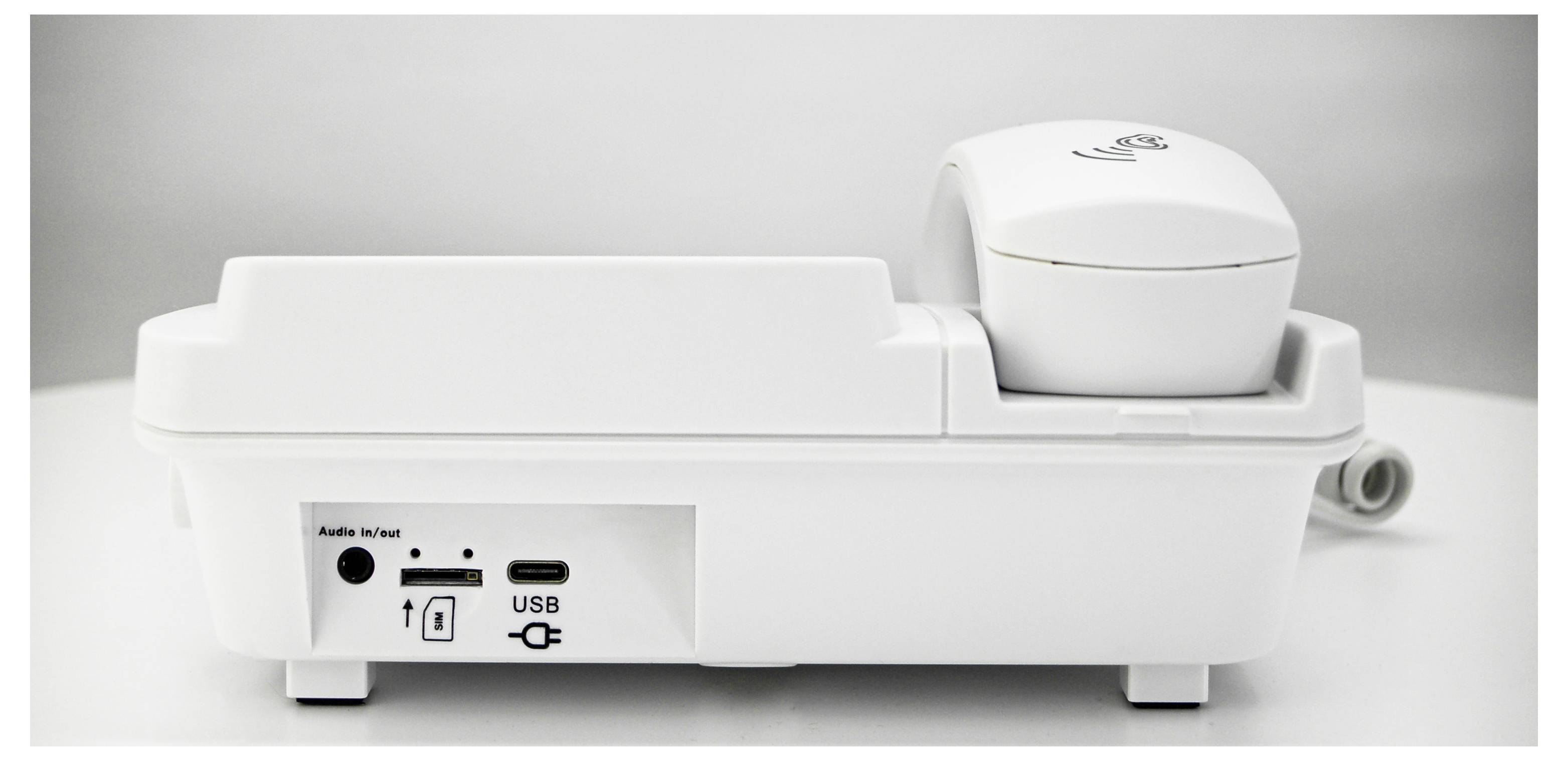 Ein weißes, modernes Gerät mit einem Kopfhörer auf der Oberseite. Auf der Vorderseite befinden sich Anschlüsse für Audio und USB.