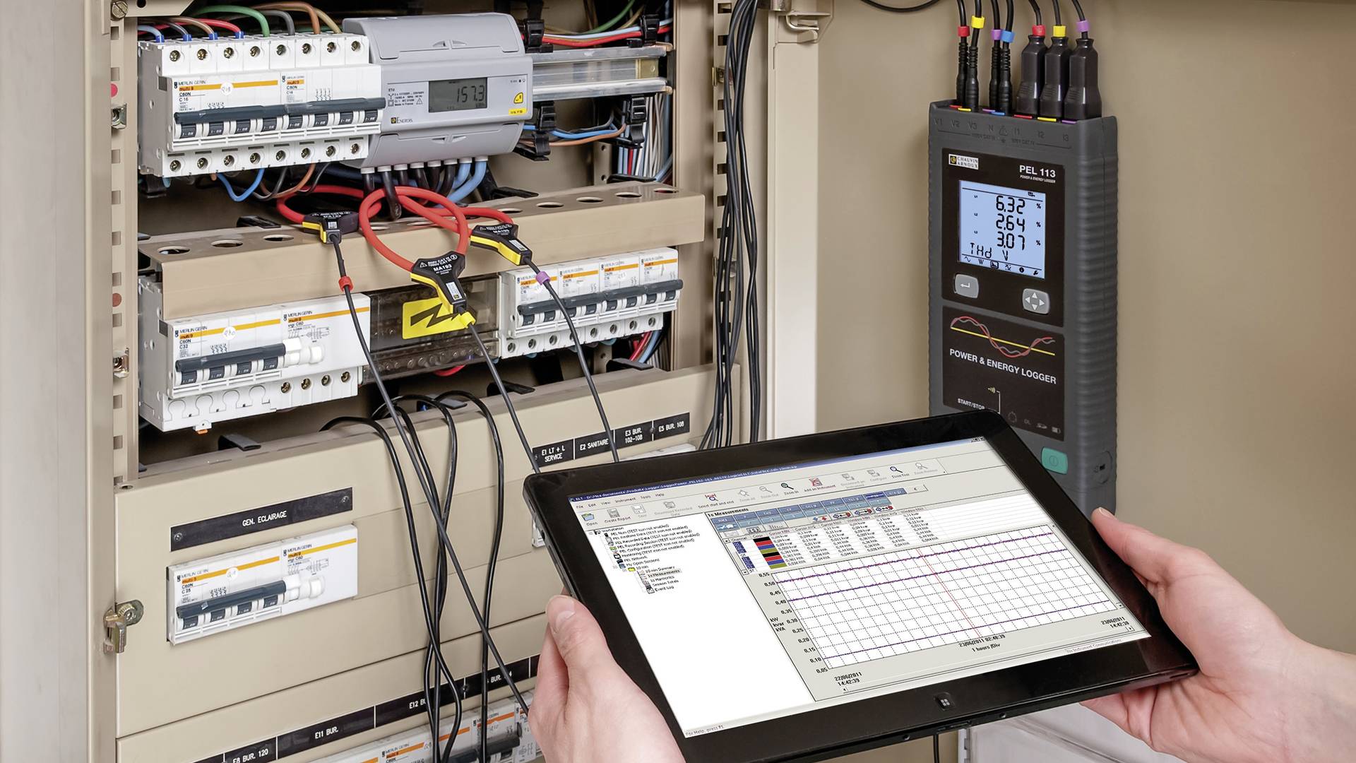 Eine Person hält ein Tablet vor einem geöffneten Schaltschrank. Das Tablet zeigt Daten, während ein Messgerät rechts elektrische Werte anzeigt.