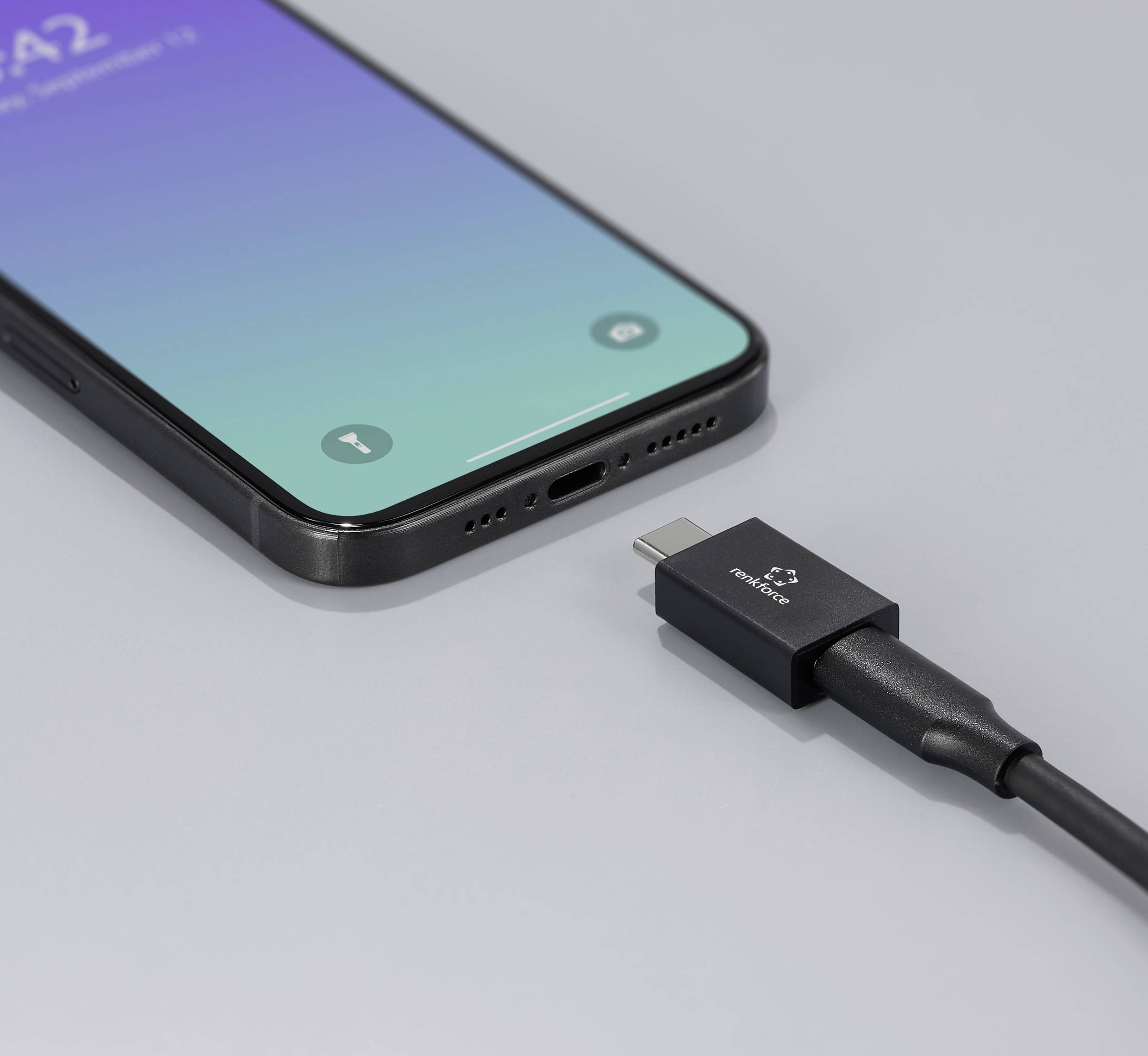 Smartphone mit blau-grünem Bildschirm wird mit einem USB-C-Kabel zum Laden verbunden.