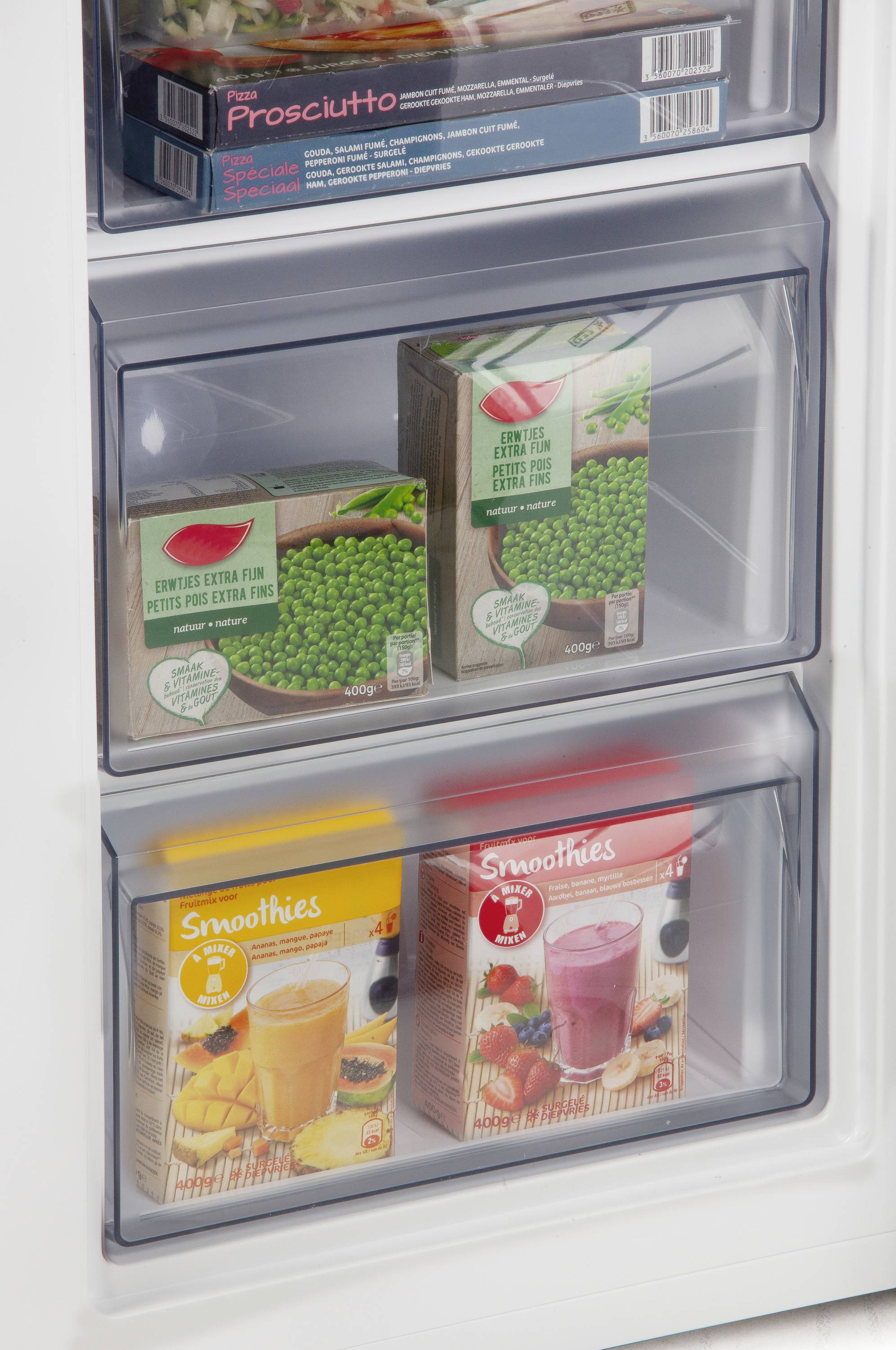 Eine Kühlschranktür mit drei Schubladen. Die oberste enthält Tiefkühl-Erbsen, die anderen zwei enthalten Smoothie-Packungen.