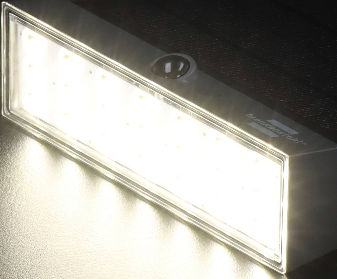 Eine leuchtende rechteckige LED-Lampe an einem schwarzen Hintergrund, die starkes weißes Licht ausstrahlt.