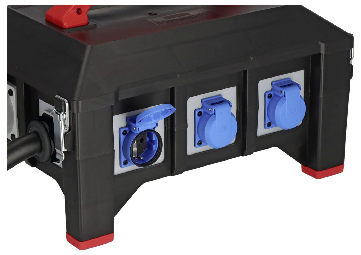 Schwarze tragbare Elektroverteilerdose mit drei blauen Stromanschlüssen und einem roten Griff, abgebildet auf weißem Hintergrund.
