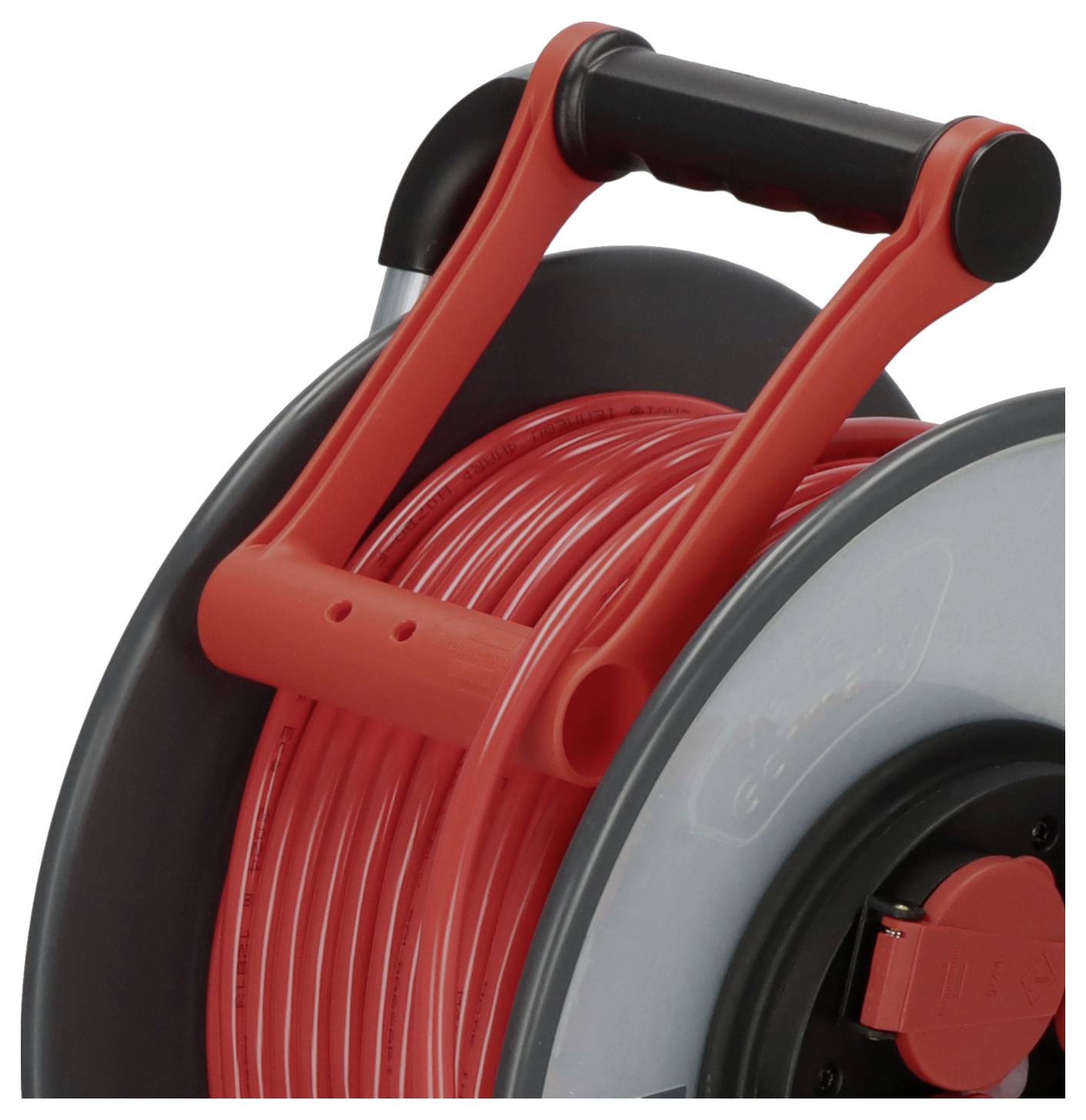 Ein rotes Verlängerungskabel auf einer schwarzen Kabeltrommel mit rotem Griff, bereit für den Einsatz im Innen- oder Außenbereich.