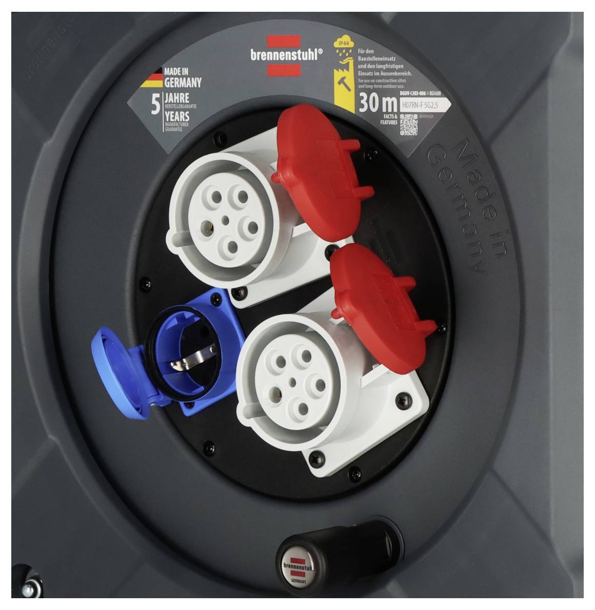 Eine Kabeltrommel von Brennenstuhl zeigt zwei rote und einen blauen Anschluss. Oben: '5 Jahre Garantie' und 'Made in Germany'.