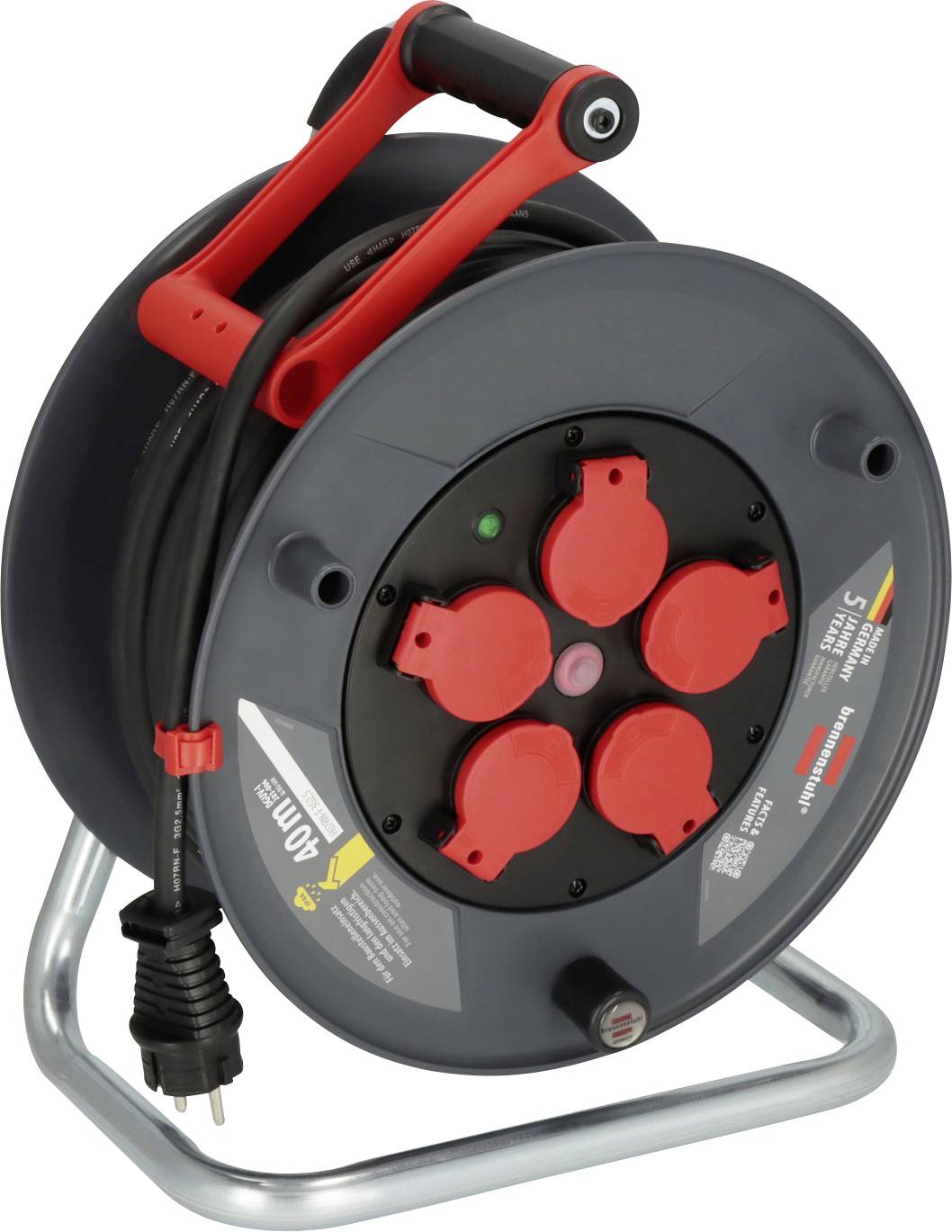 Eine schwarze Kabeltrommel mit rotem Griff und vier Steckdosen. Sie steht auf einem Metallgestell und hat ein schwarzes Kabel mit Stecker.