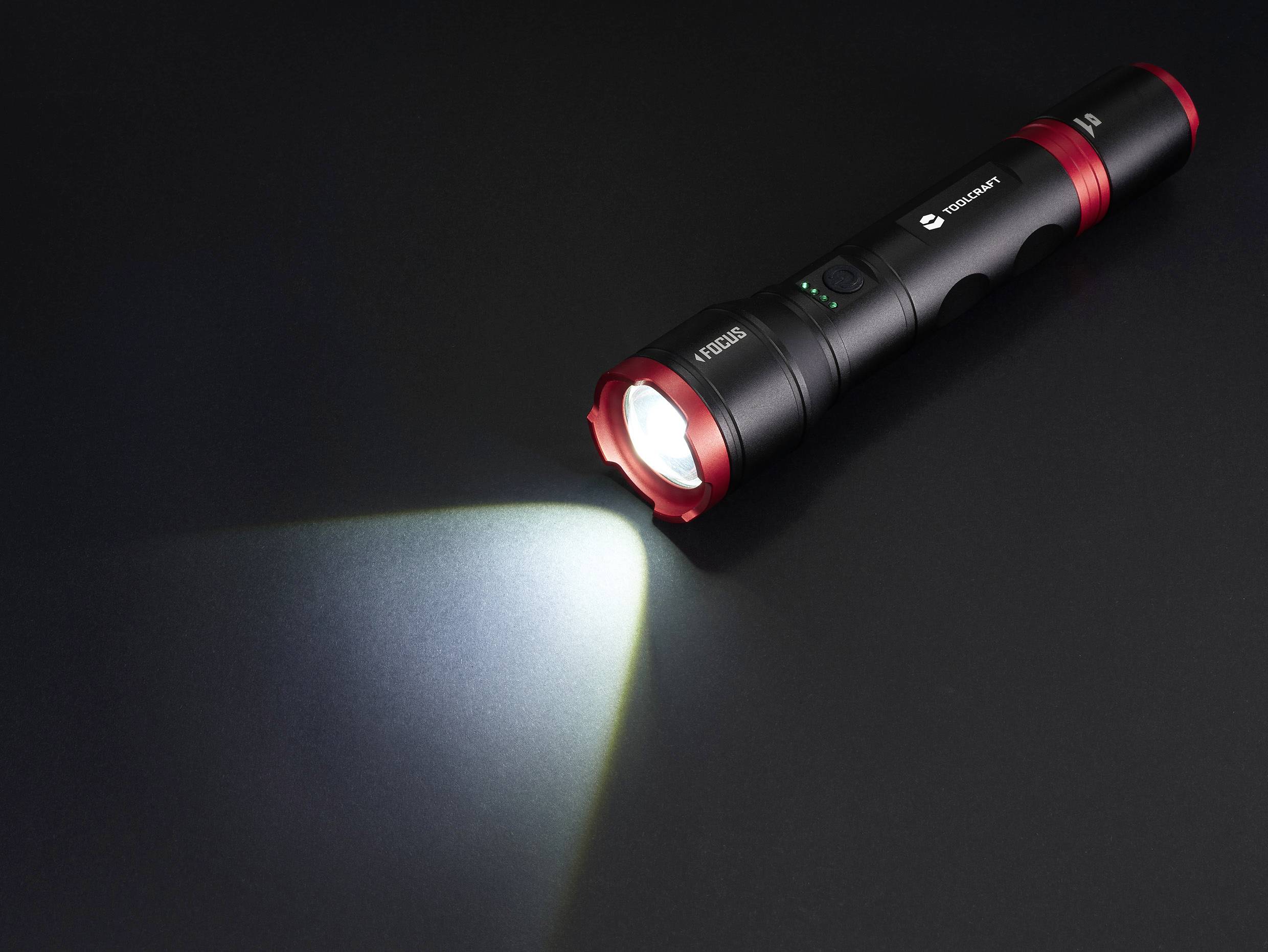 Taschenlampe leuchtet auf schwarzem Hintergrund, zeigt eine fokussierte Lichtstrahl nach links.