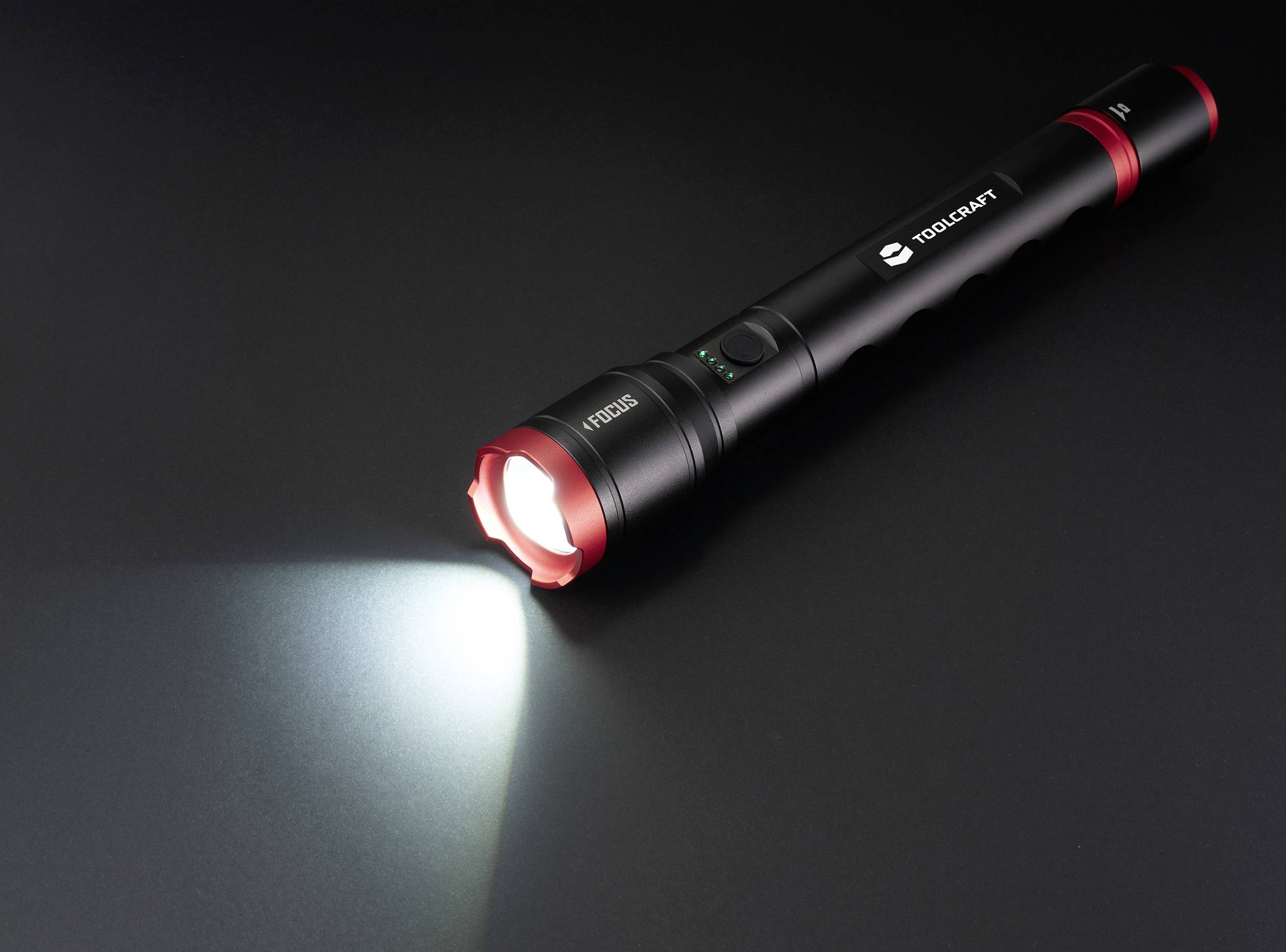 Taschenlampe auf schwarzem Hintergrund strahlt helles Licht aus.