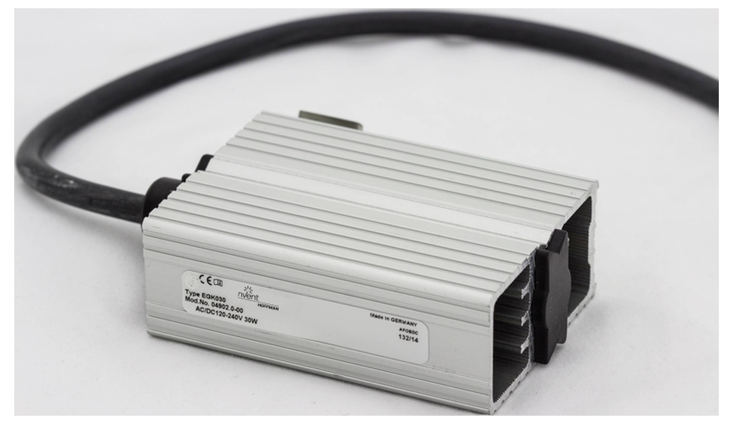 Ein rechteckiges, silbernes elektronisches Gerät mit schwarzem Kabel. Auf der Oberseite befinden sich technische Spezifikationen.