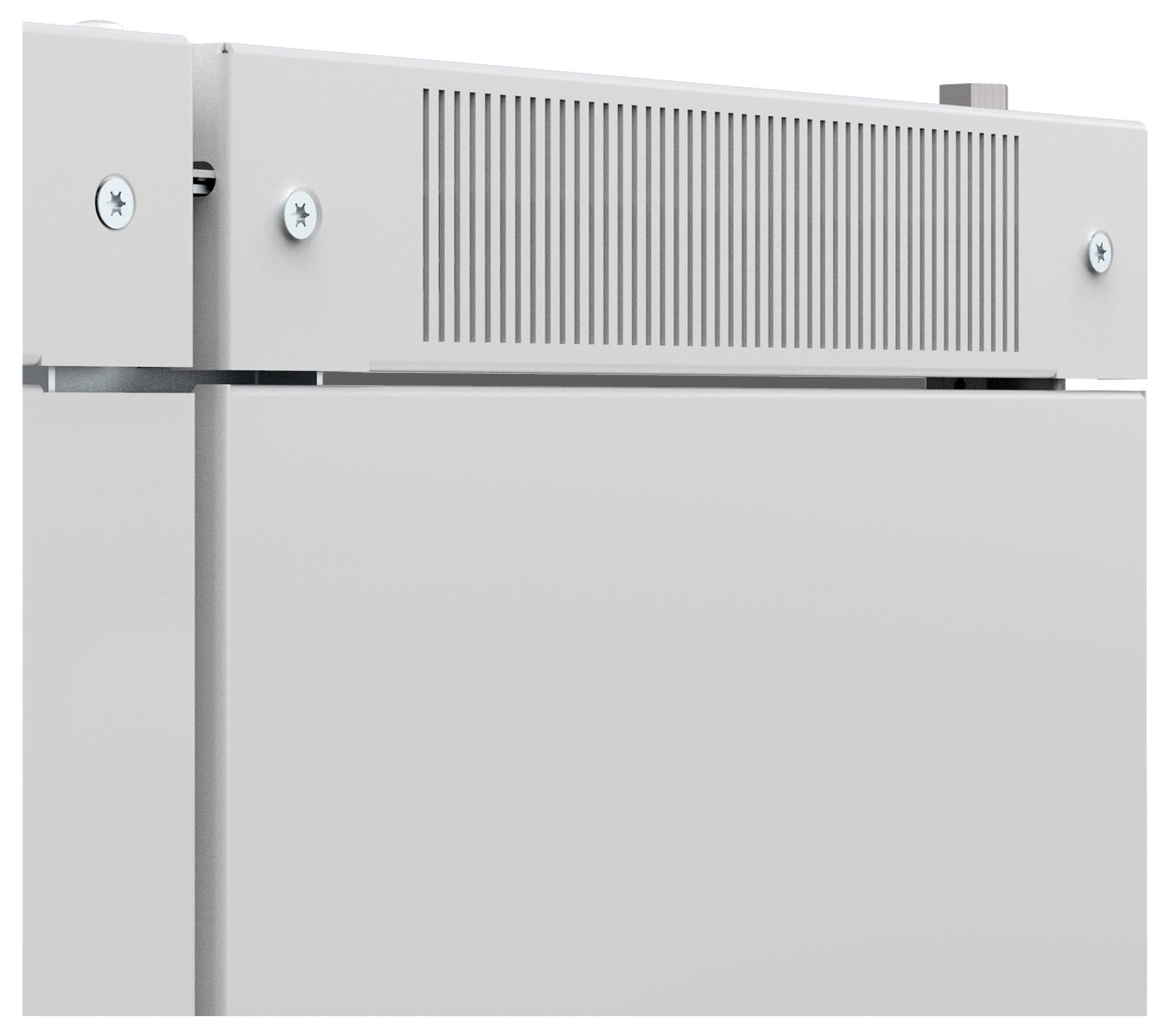 Teil eines metallischen Geräts, vermutlich ein Kühlschrank, mit Lüftungsschlitzen und sichtbaren Schrauben an der oberen Kante.