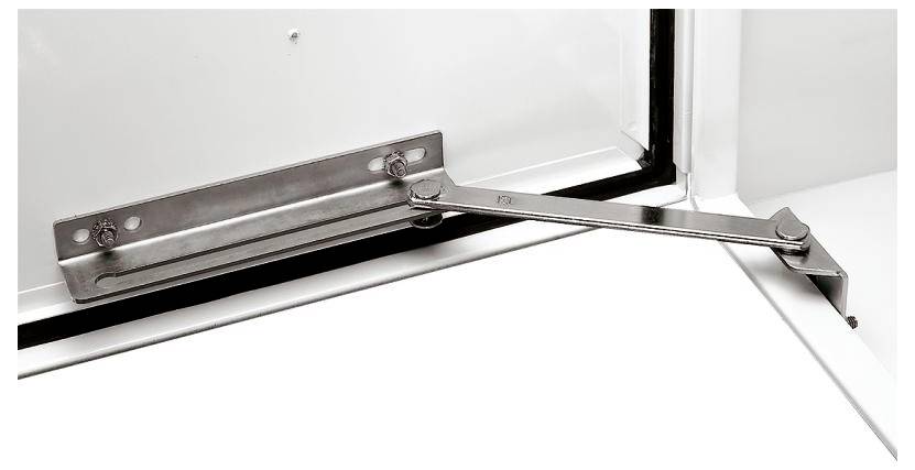 Metallischer Fensteröffnungsbegrenzer, montiert, öffnet sich von links nach rechts, hält Fenster auf Spalt geöffnet.