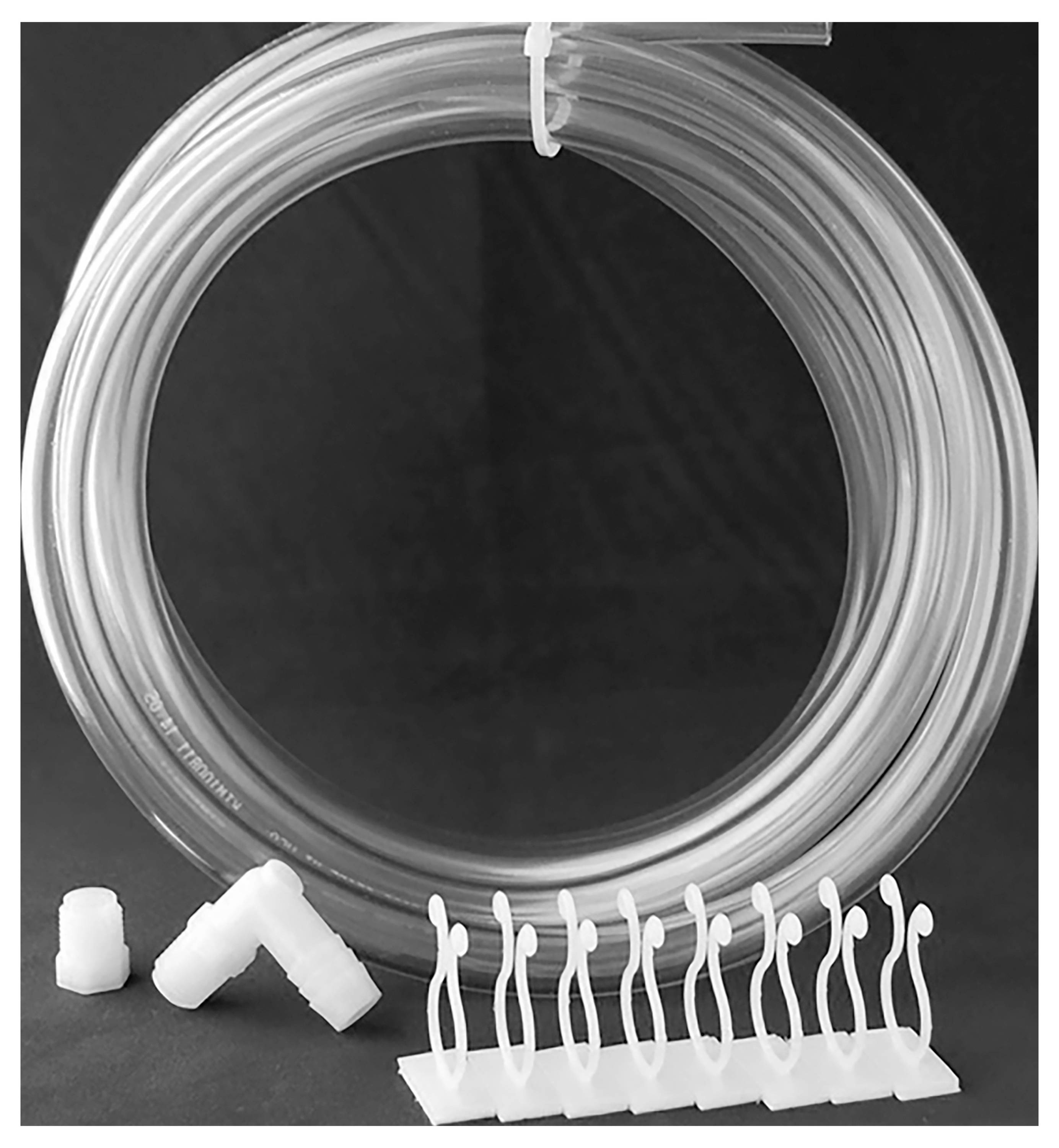 Eine gerollte, transparente Röhre mit weißen Steckverbindern und einer Reihe von weißen, geschwungenen Halterungen auf schwarzem Hintergrund.