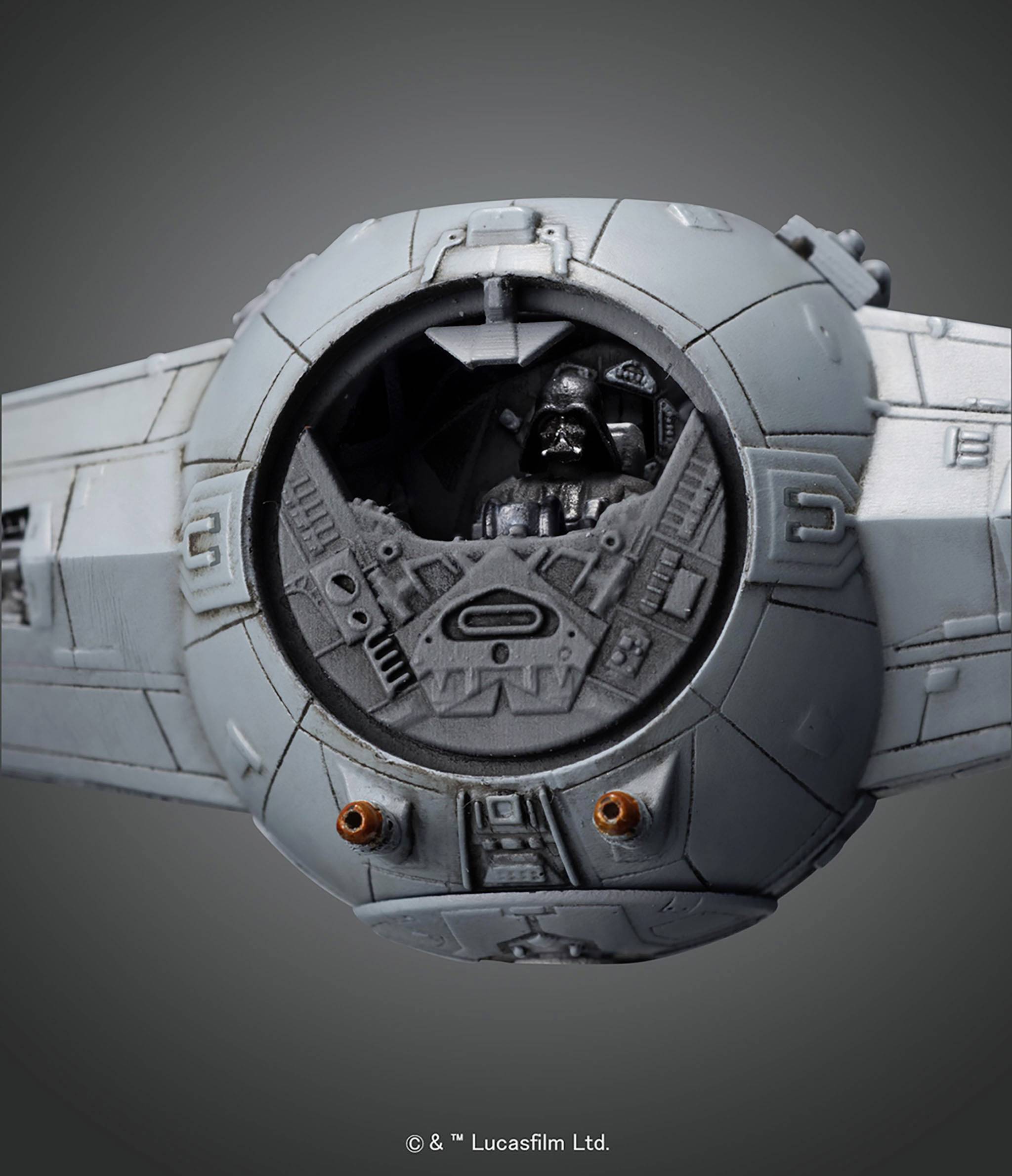 Ein graues Raumschiff mit runder Cockpitkabine, darin eine schwarze Figur mit Helm. Hintergrund ist dunkelgrau.