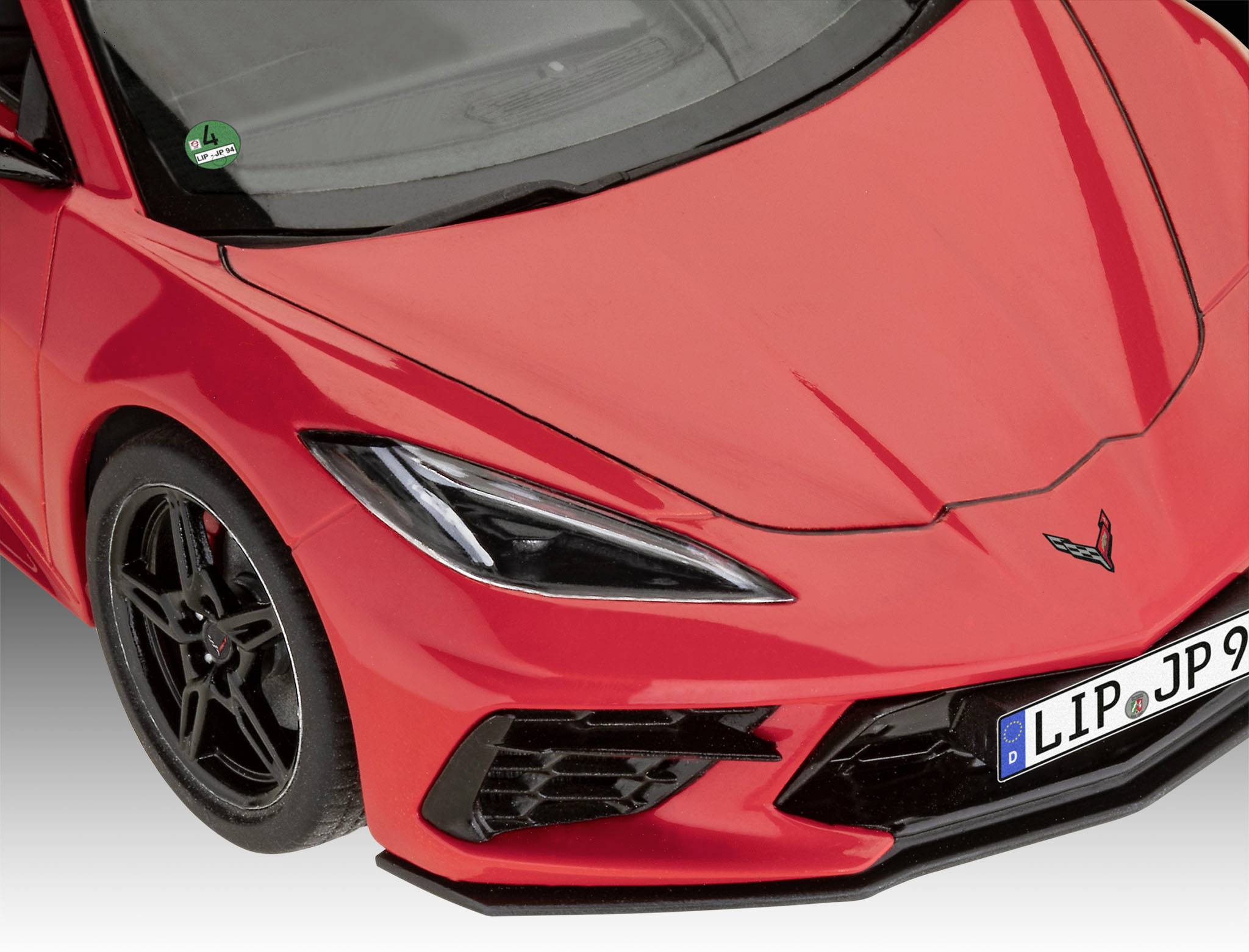 Rotes Sportauto von vorne fotografiert, modernes Design, schwarze Felgen, Teil eines Kennzeichens sichtbar.