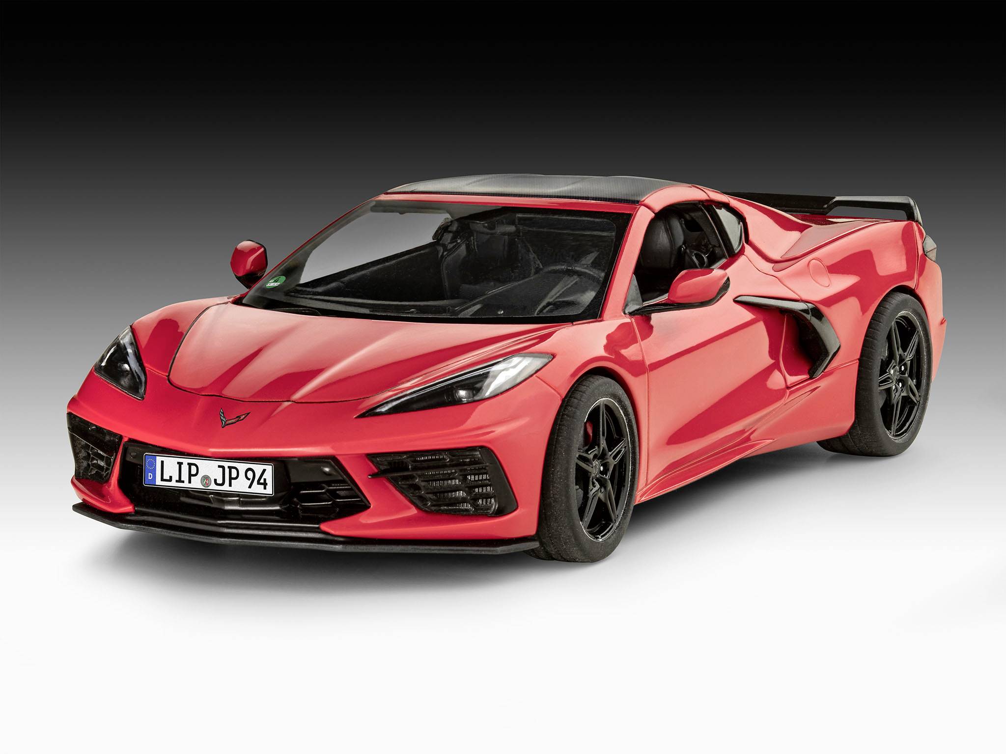 Ein roter Sportwagen steht auf hellem Boden vor einem dunklen Hintergrund. Er hat ein modernes Design und schwarze Felgen.