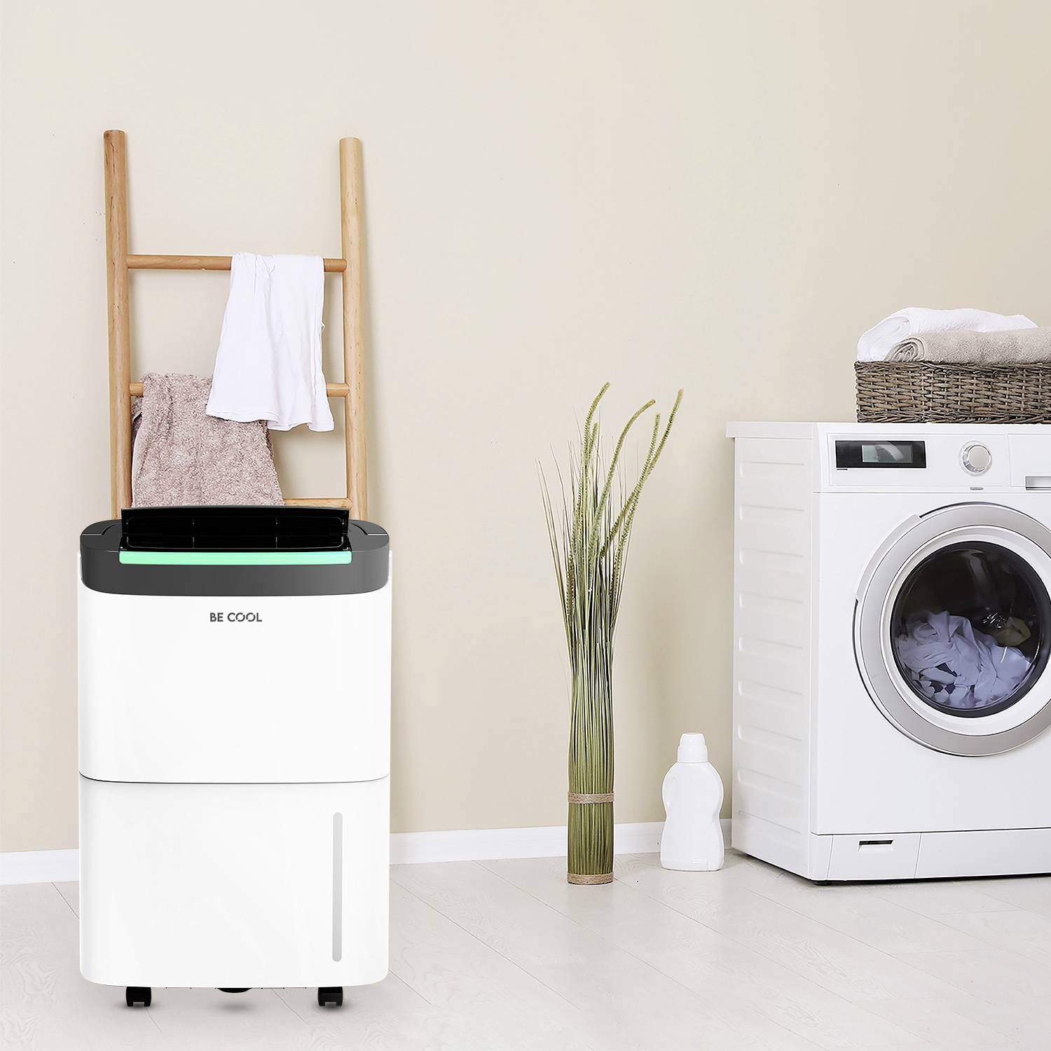 Aufgeräumte Waschküche mit Wäschetrockner und Topfpflanze neben moderner Waschmaschine, weiße Handtücher auf Holzleiter.