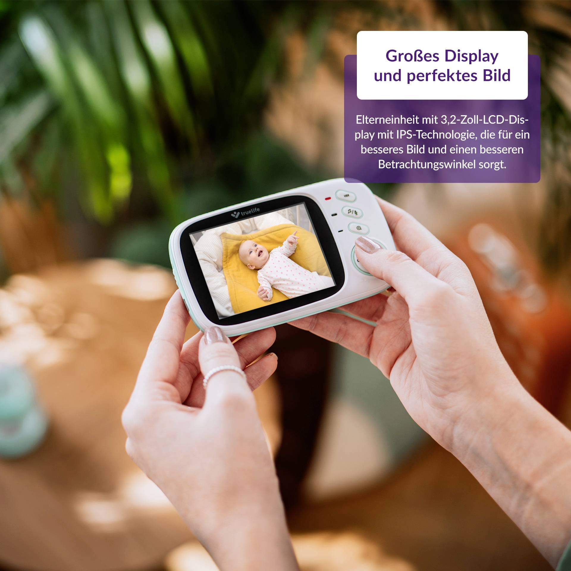 Eine Person hält ein Babyphone mit großem Display, das ein Baby zeigt. Text auf Display: 'Großes Display und perfektes Bild'.