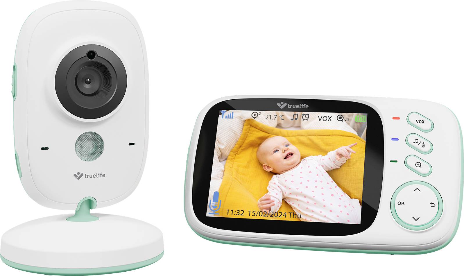 Ein Babyphone mit Kamera und Bildschirm zeigt ein lächelndes Baby auf einer gelben Decke. Der Bildschirm zeigt Datum und Uhrzeit.