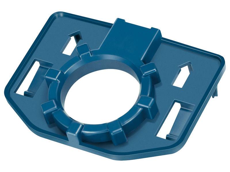 Blaues Kunststoffbauteil mit rundem Mittelteil und rechteckiger Grundform, vermutlich Adapter oder Halterung, leere Öffnungen sichtbar.