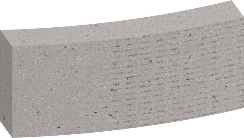 Ein gebogener grauer Betonblock, der eine gleichmäßige Oberfläche und kleine Einschlüsse aufweist.