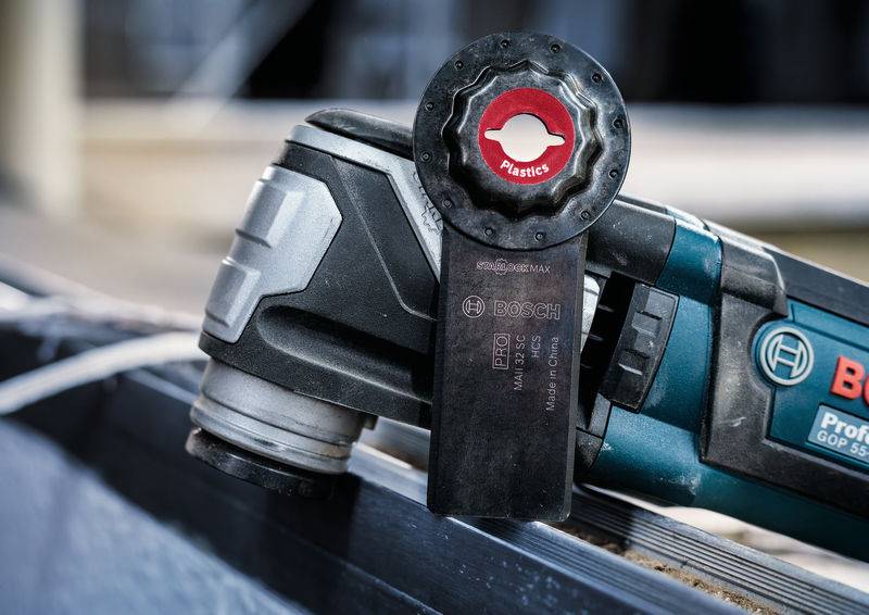 Ein Multifunktionswerkzeug mit Kunststoffsägeblatt vor einem blauen Hintergrund, geeignet für Präzisionsschnitte in verschiedenen Materialien.