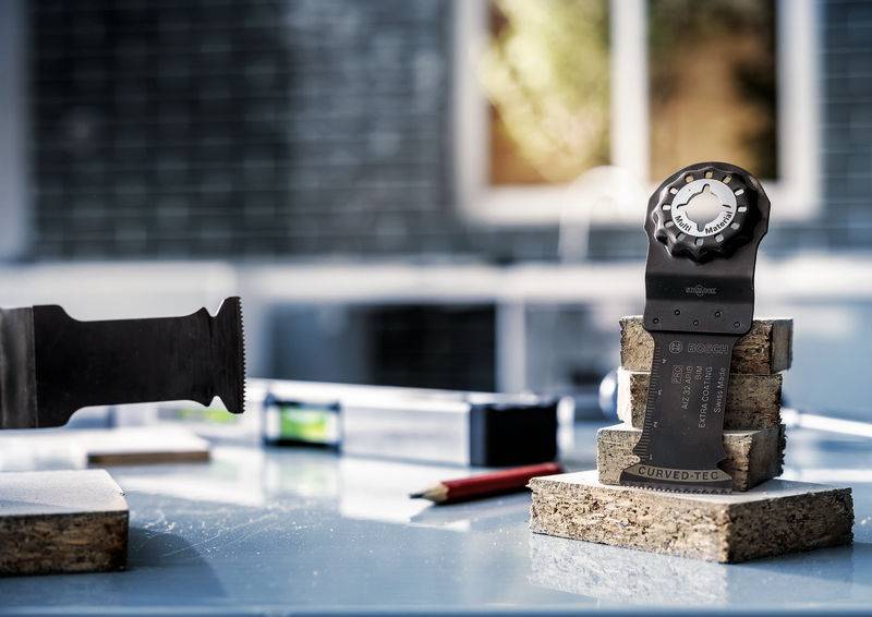 Werkzeugschneide befestigt auf einem Korkblock im Vordergrund. Verschwommene Hintergrunddetails eines hellen Arbeitsbereichs.