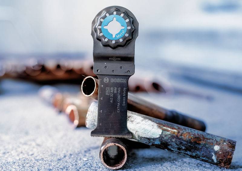 Eine Säge mit speziellem Aufsatz schneidet durch alte Rohre. Die Säge zeigt die Marke Bosch und ist für präzise Arbeiten geeignet.