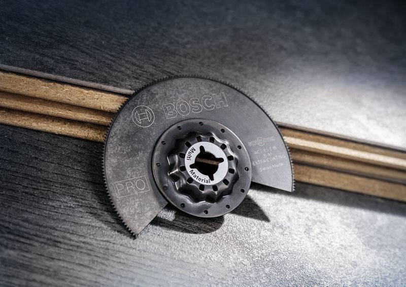 Ein halbmondförmiges Sägeblatt der Marke Bosch liegt auf Holzleisten. Text auf dem Sägeblatt: 'BIM Multi Material'.