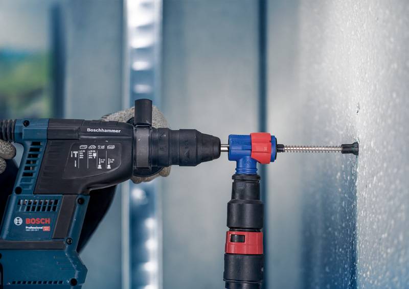 Eine Person verwendet eine elektrische Bohrmaschine, um ein Loch in eine Metallwand zu bohren. Die Bohrmaschine hat mehrere Einstellungen.
