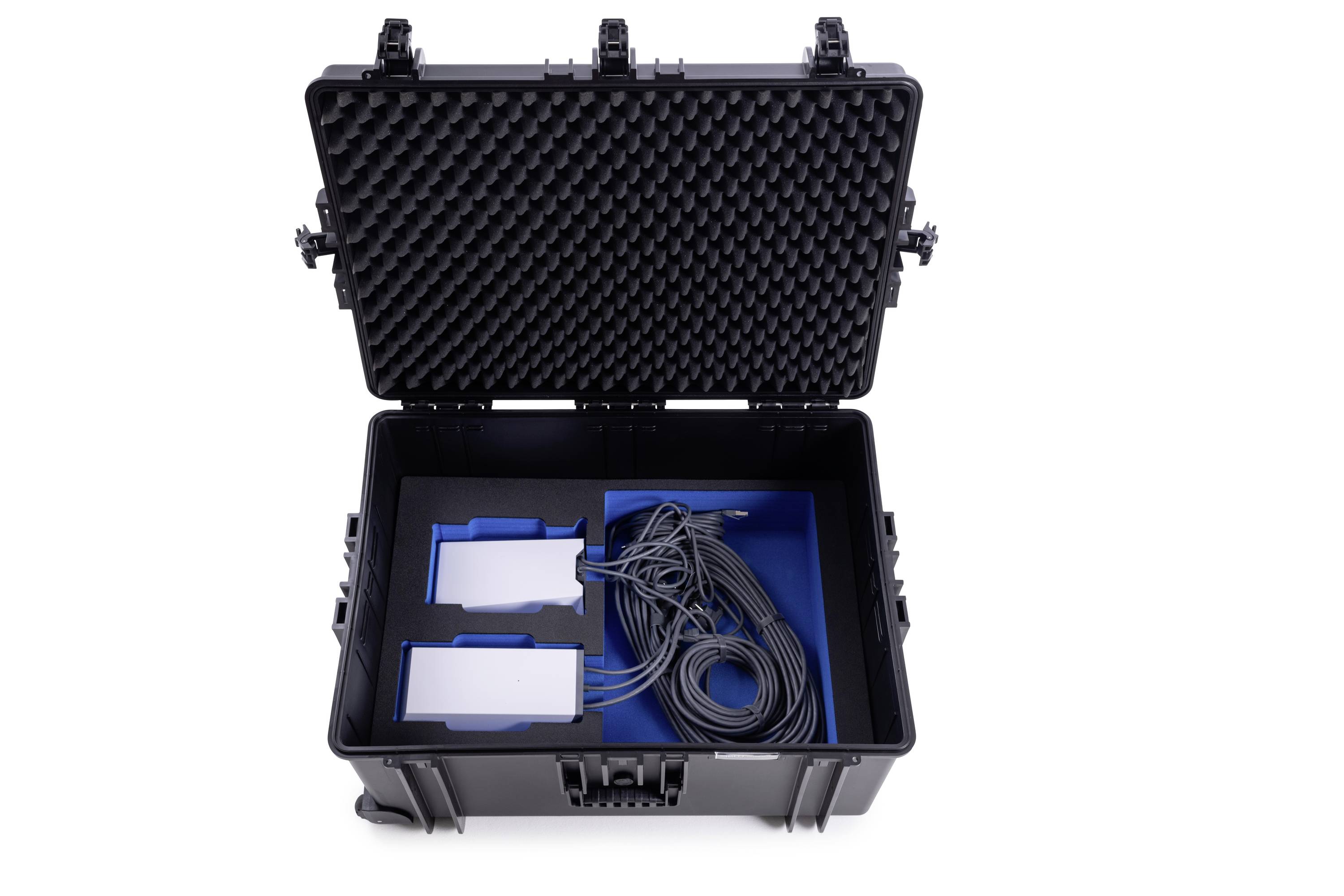 Ein schwarzer Transportkoffer ist geöffnet und zeigt Kabel und zwei rechteckige Geräte in blauen Fächern.