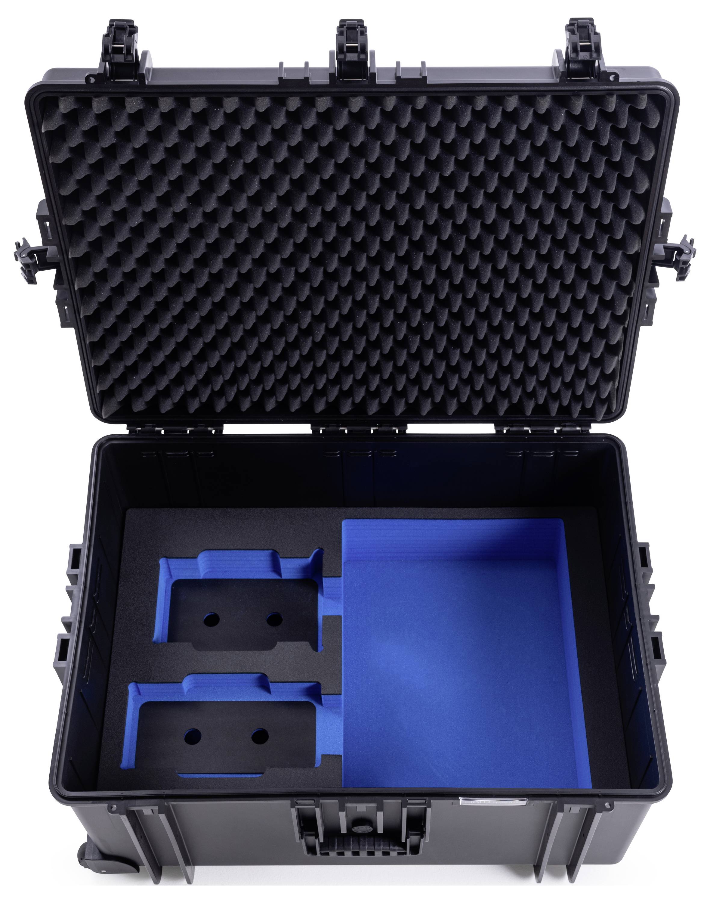 Ein offener schwarzer Transportkoffer mit Schaumstoffeinsätzen für sichere Lagerung. Links zwei vertiefte Fächer, rechts ein großes Fach.