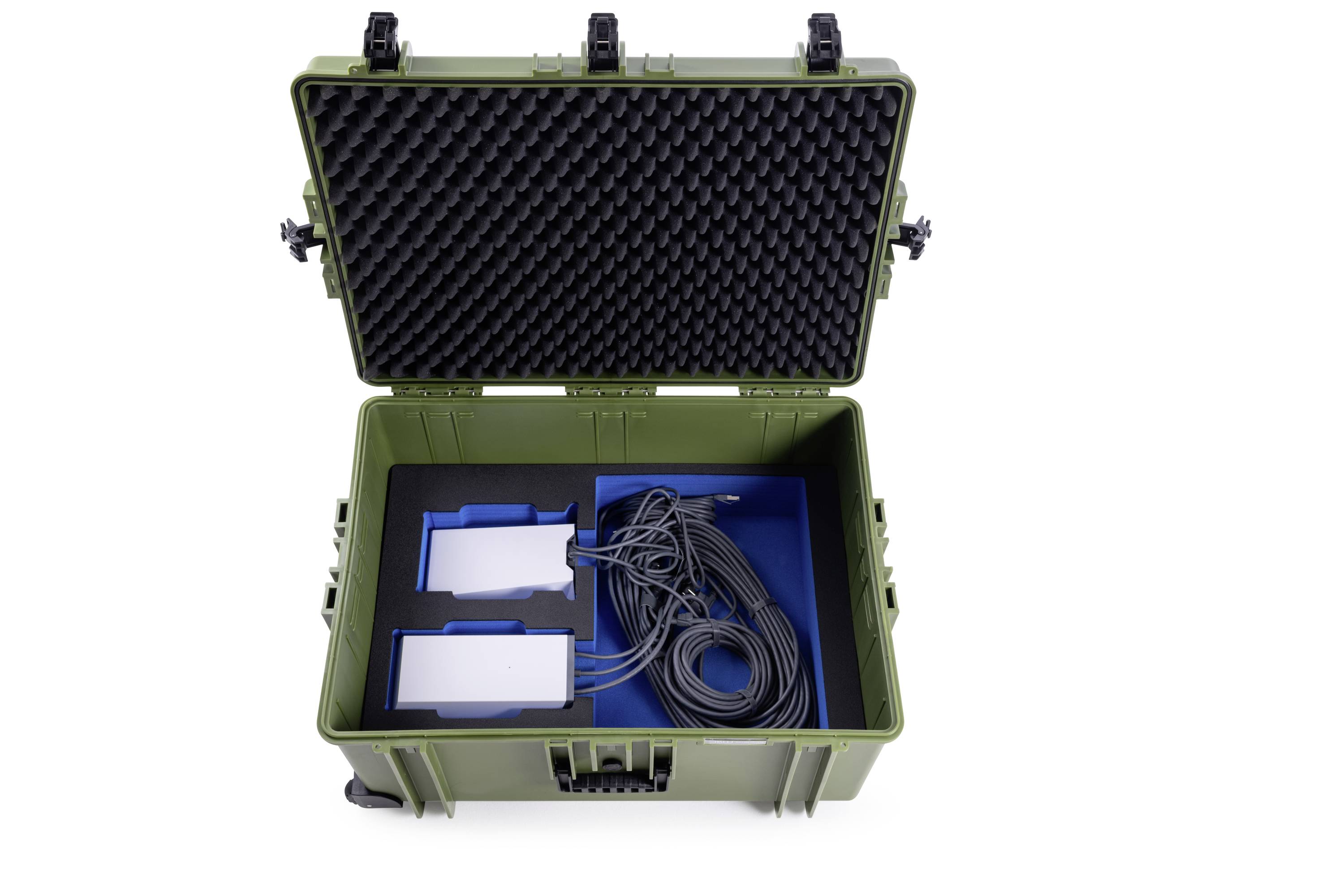 Ein grüner, geöffneter Koffer mit Schaumstoffpolsterung zeigt Kabel und zwei weiße Geräte in blauen Halterungen.