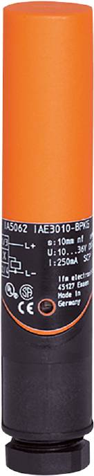 Nahaufnahme eines orangefarbenen elektrischen Sensors mit weißen technischen Spezifikationen auf schwarzem Hintergrund.