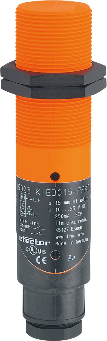 Ein zylindrischer, orangefarbener Sensorkörper mit schwarzem Punkt oben. Modellnummer 'KIE3015-FPKG/US' und Spannung '10...55 V DC' sind sichtbar.
