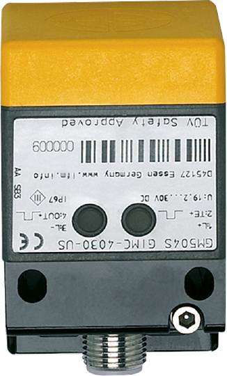Ein weißes und gelbes elektronisches Gerät mit Beschriftungen und Barcodes auf der Vorderseite, vermutlich ein Sensor oder Schalter.
