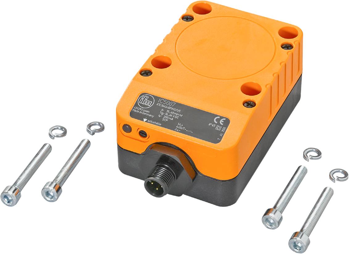 Ein rechteckiger, orangefarbener Sensor mit schwarzen Details, Schrauben und Muttern daneben. Er dient zur Überwachung in industriellen Anwendungen.