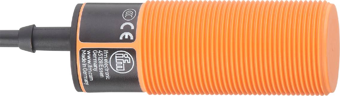 Nahaufnahme eines zylindrischen, orange-schwarzen Objekts mit Gewinde und verschiedenen Symbolen, möglicherweise technische Komponente.