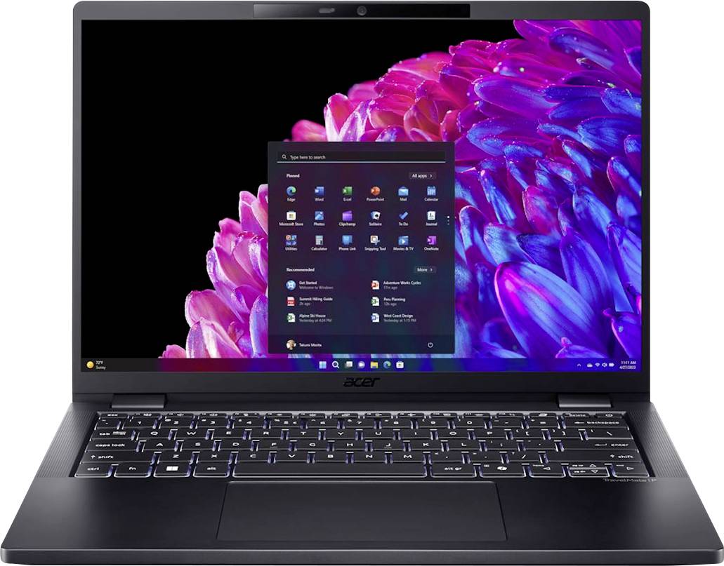 Ein Laptop mit schwarzem Gehäuse zeigt den Windows-Startbildschirm. Der Hintergrund zeigt ein buntes Blumenmotiv in Pink und Blau.