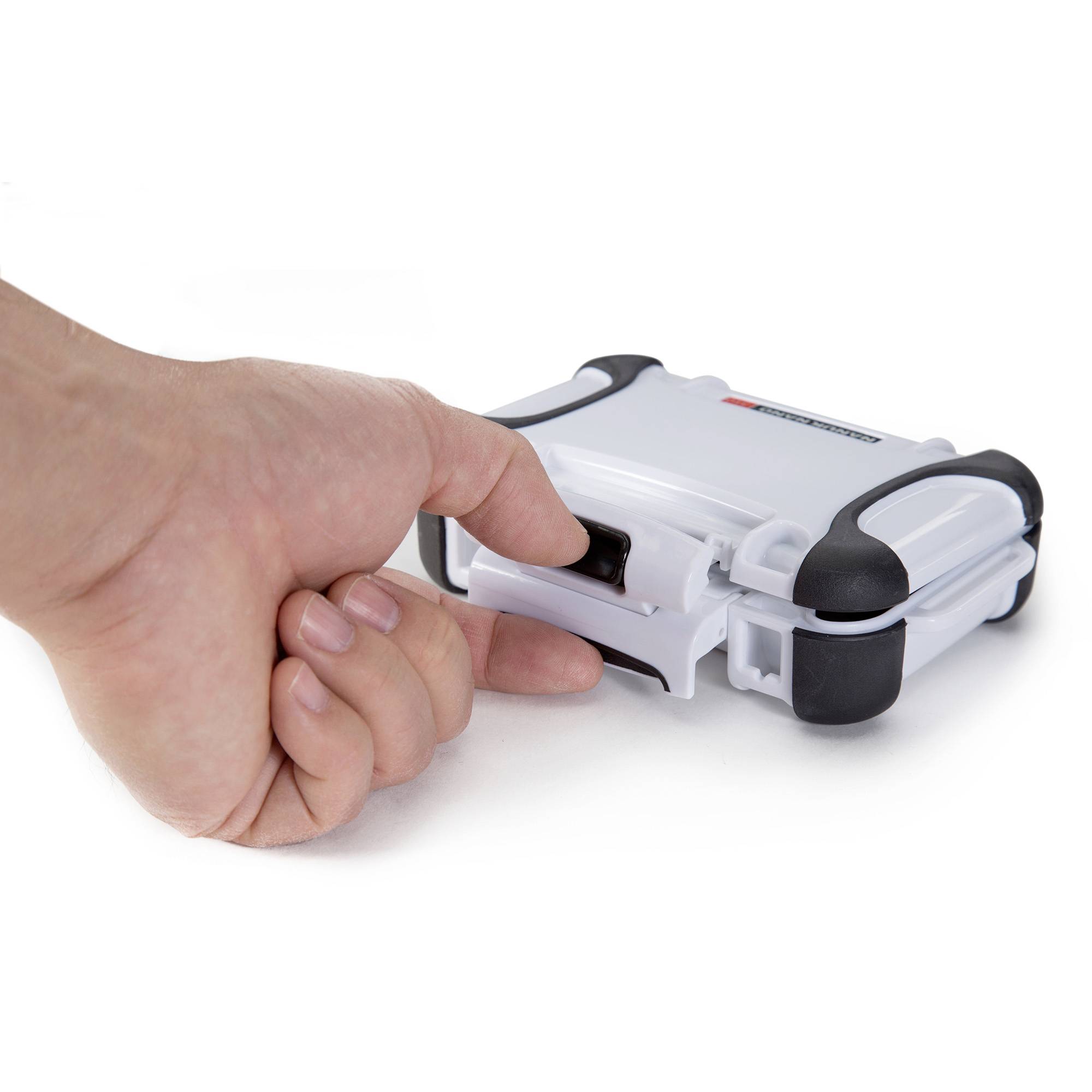 Eine Hand drückt einen Knopf an einem kleinen, weißen Gerät mit schwarzen Ecken.